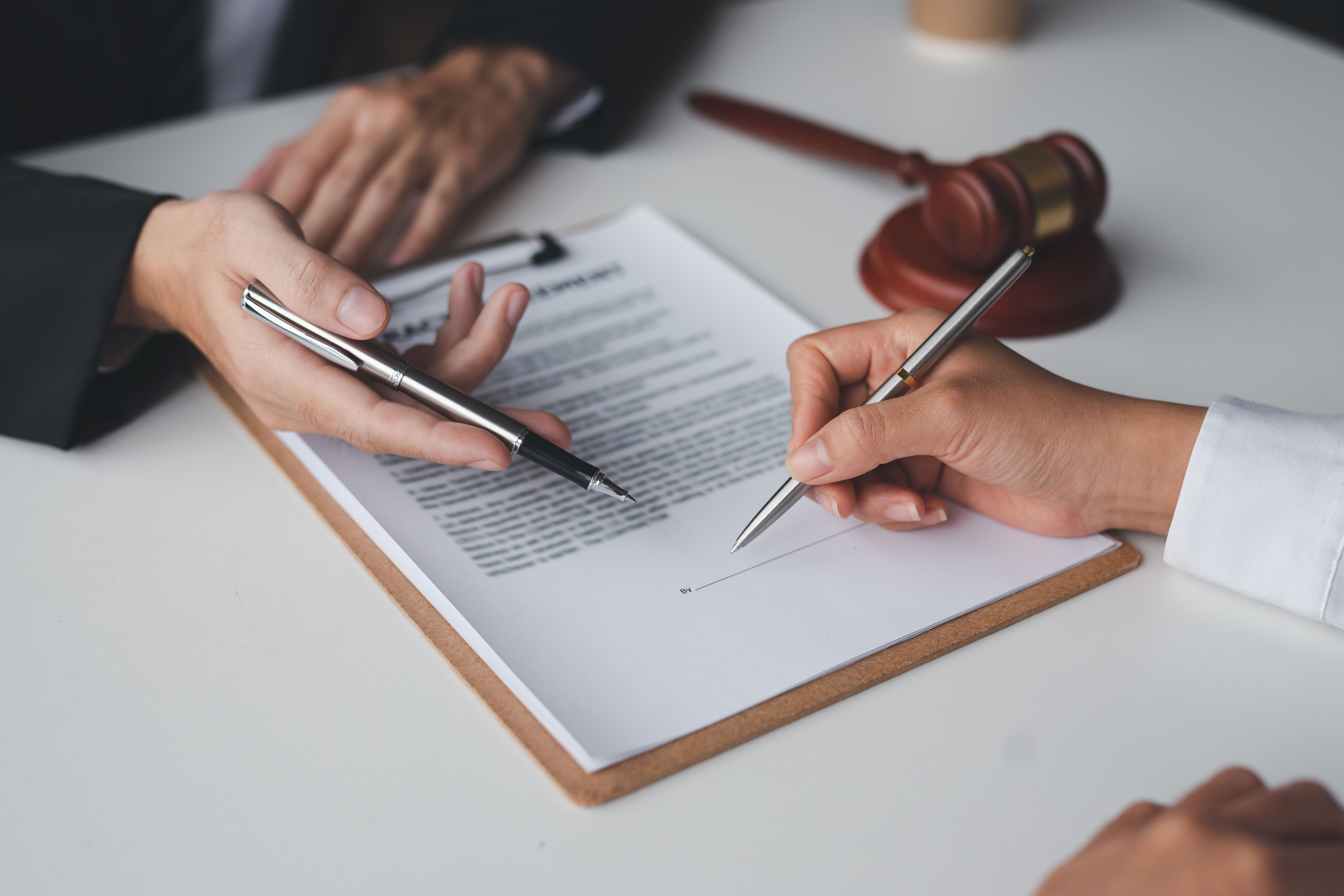 Close-up of nonprofit compliance paperwork being signed with gavel in background, symbolizing Florida charity registration requirements.