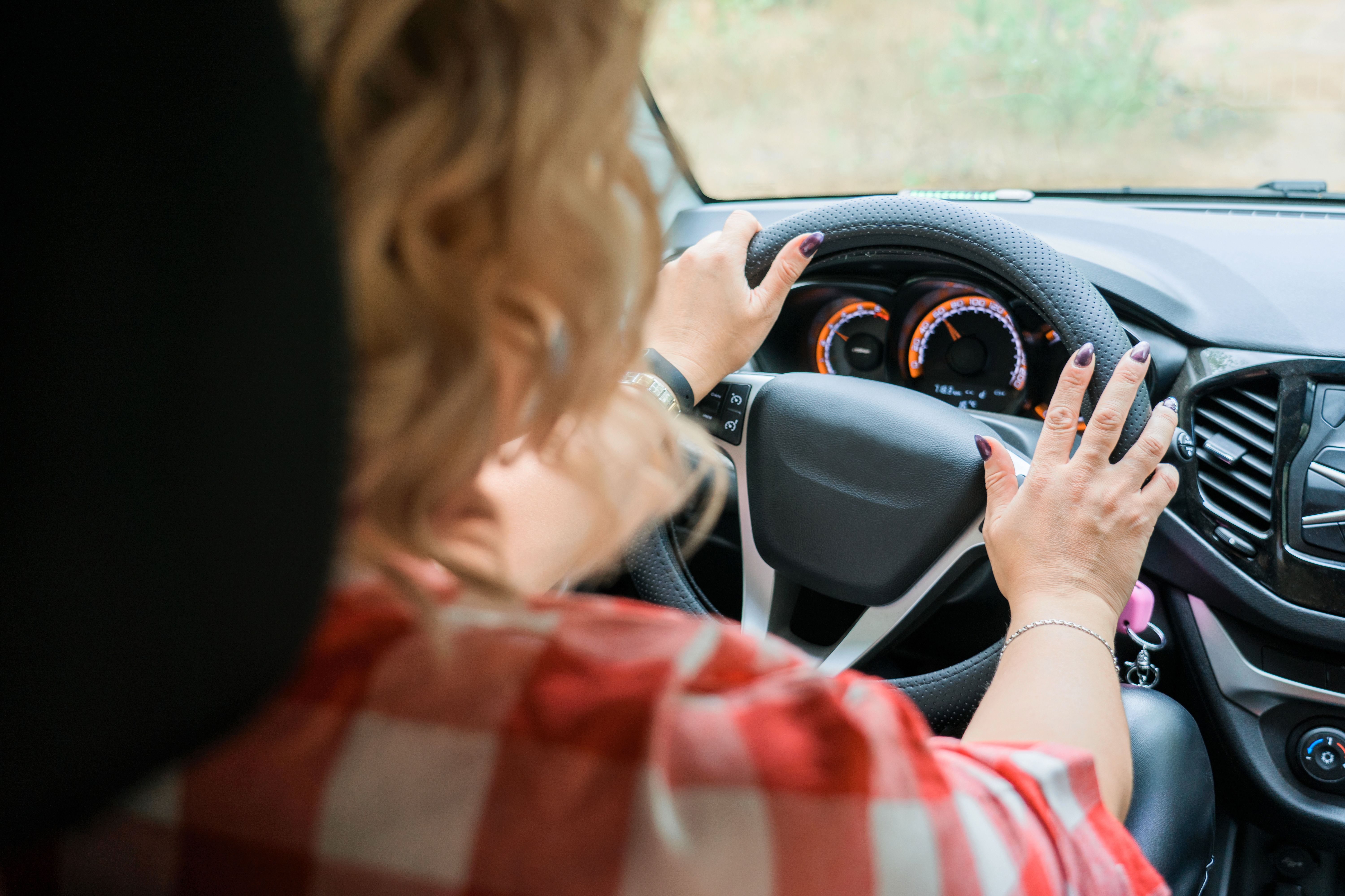 Adult blonde woman driving a car, inside view Adult blonde woman driving a car, inside view