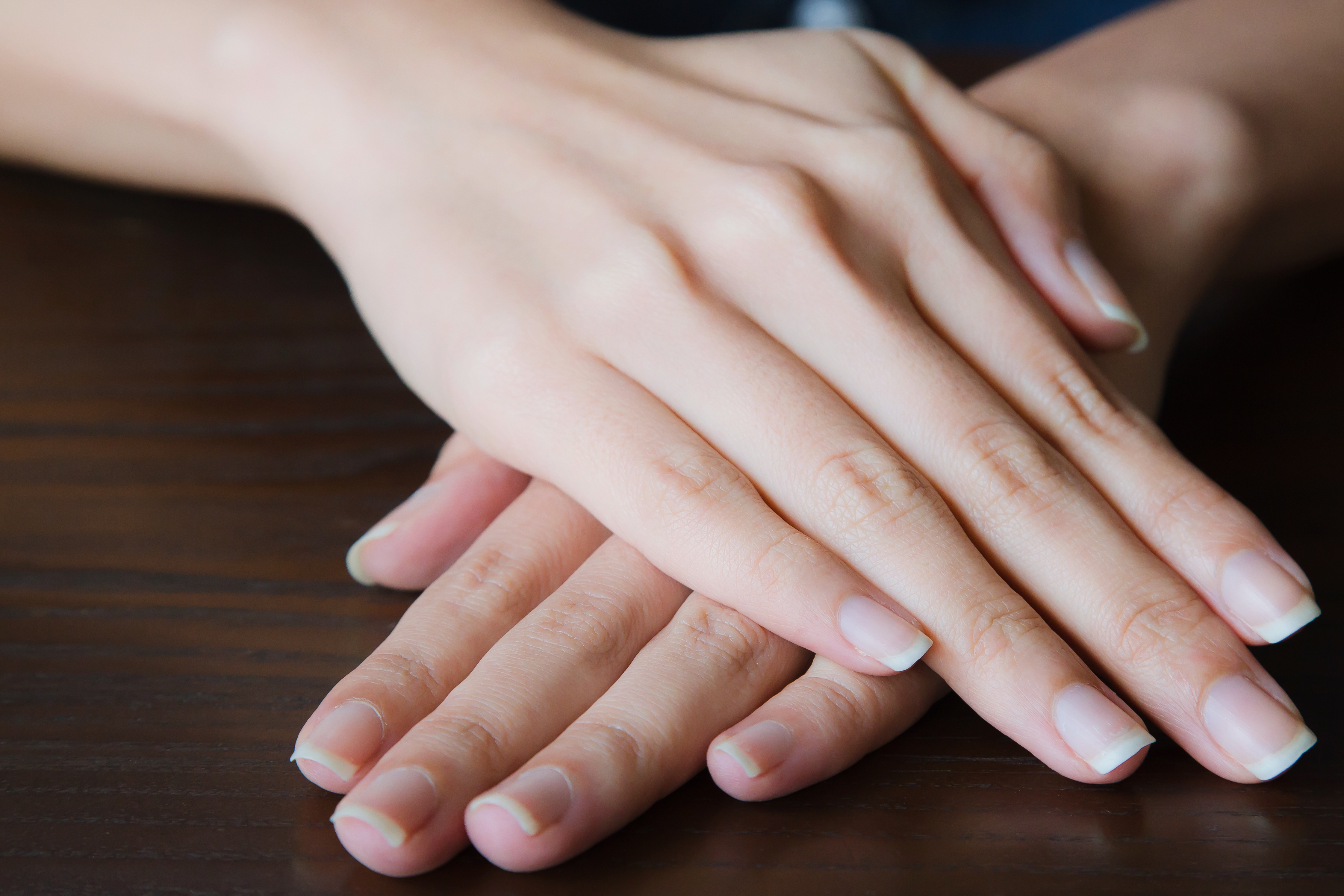 Woman hands showing with beautiful manicure on wooden background.