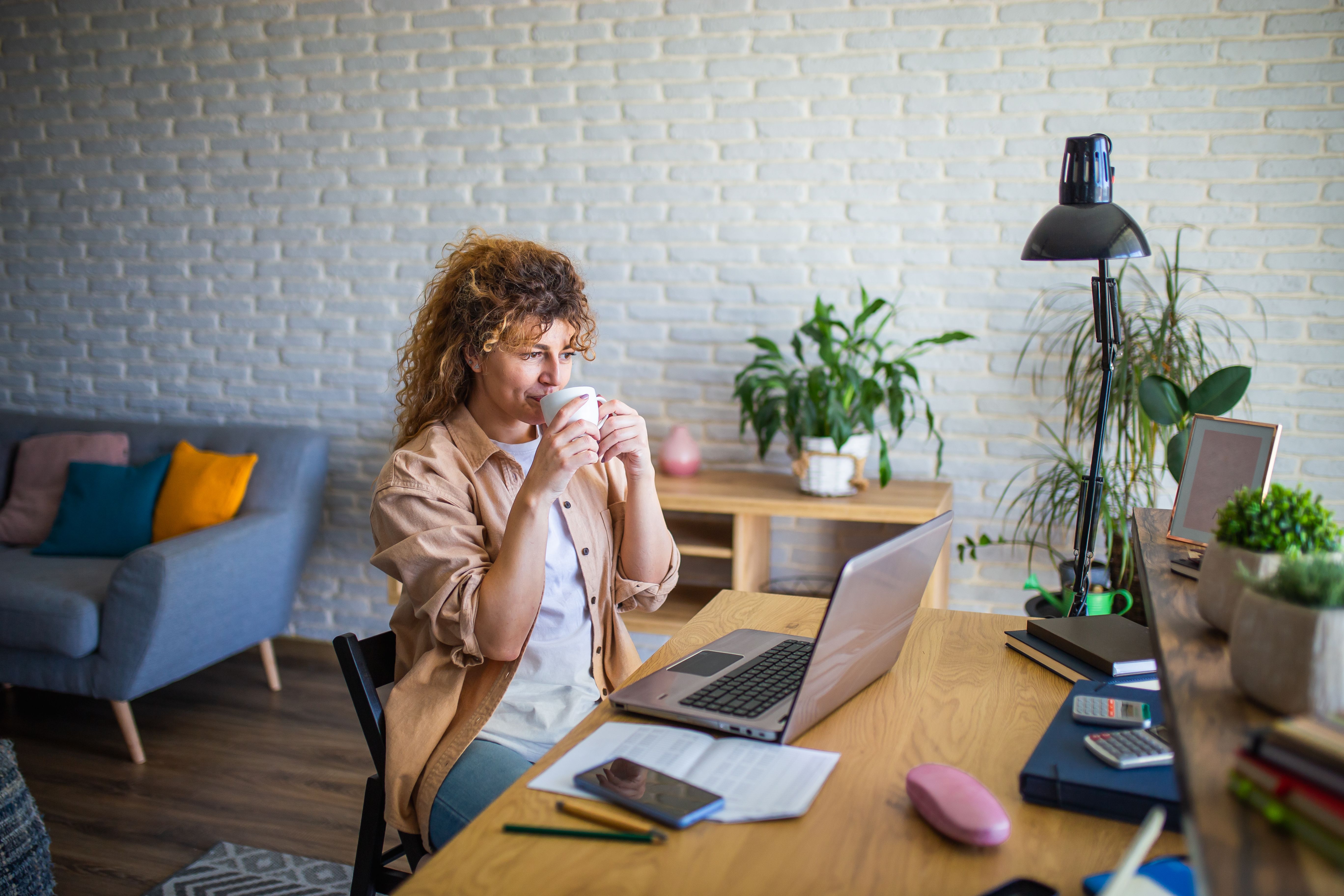 Young female entrepreneur working on a laptop and drinking coffee
