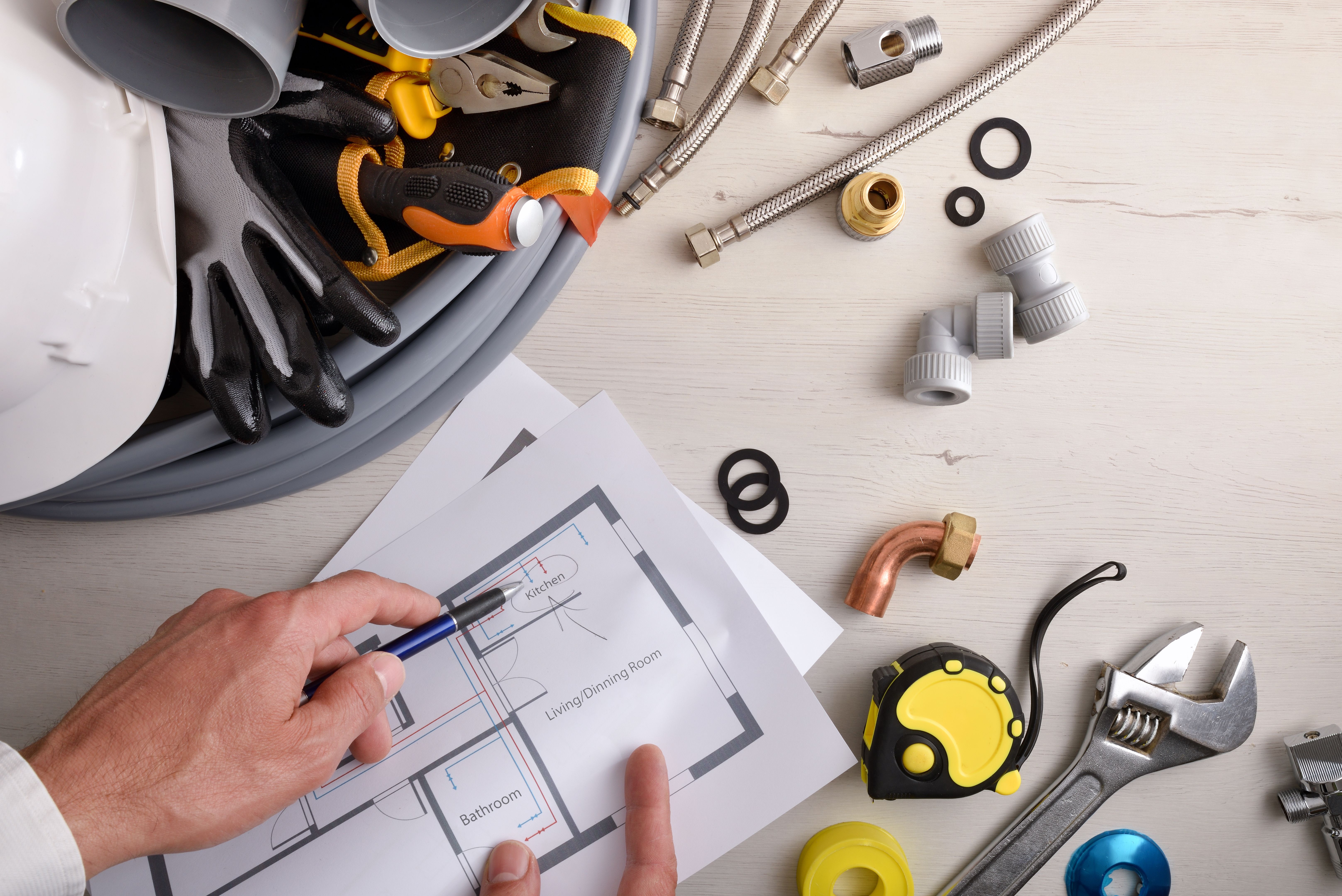 Engineer showing scheme of water installation on table with tools