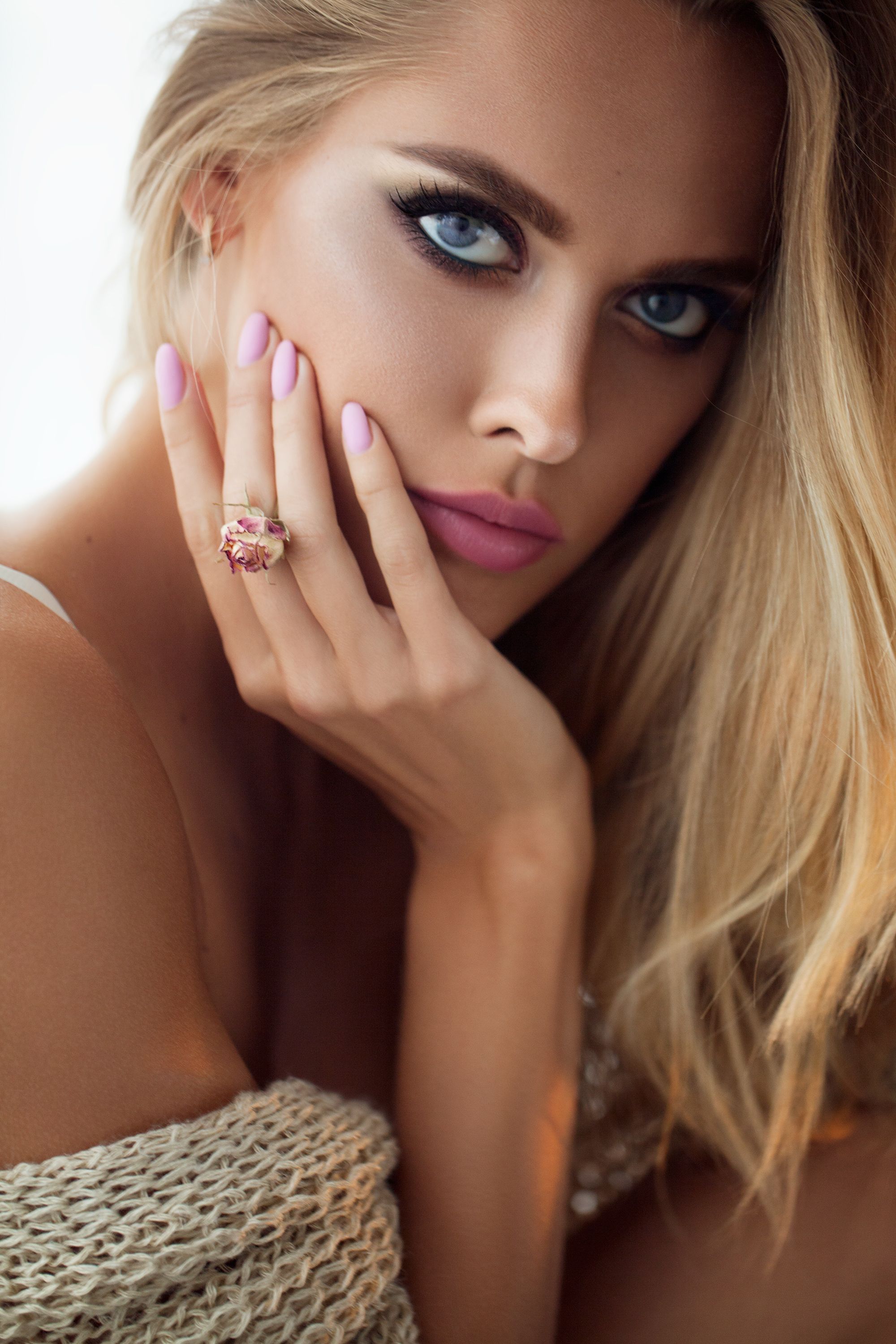 Beauty Fashion Model Woman face. Portrait with pink Rose flower. Pink Lips and Nails. Beautiful Blonde Woman with Perfect Makeup and Manicure