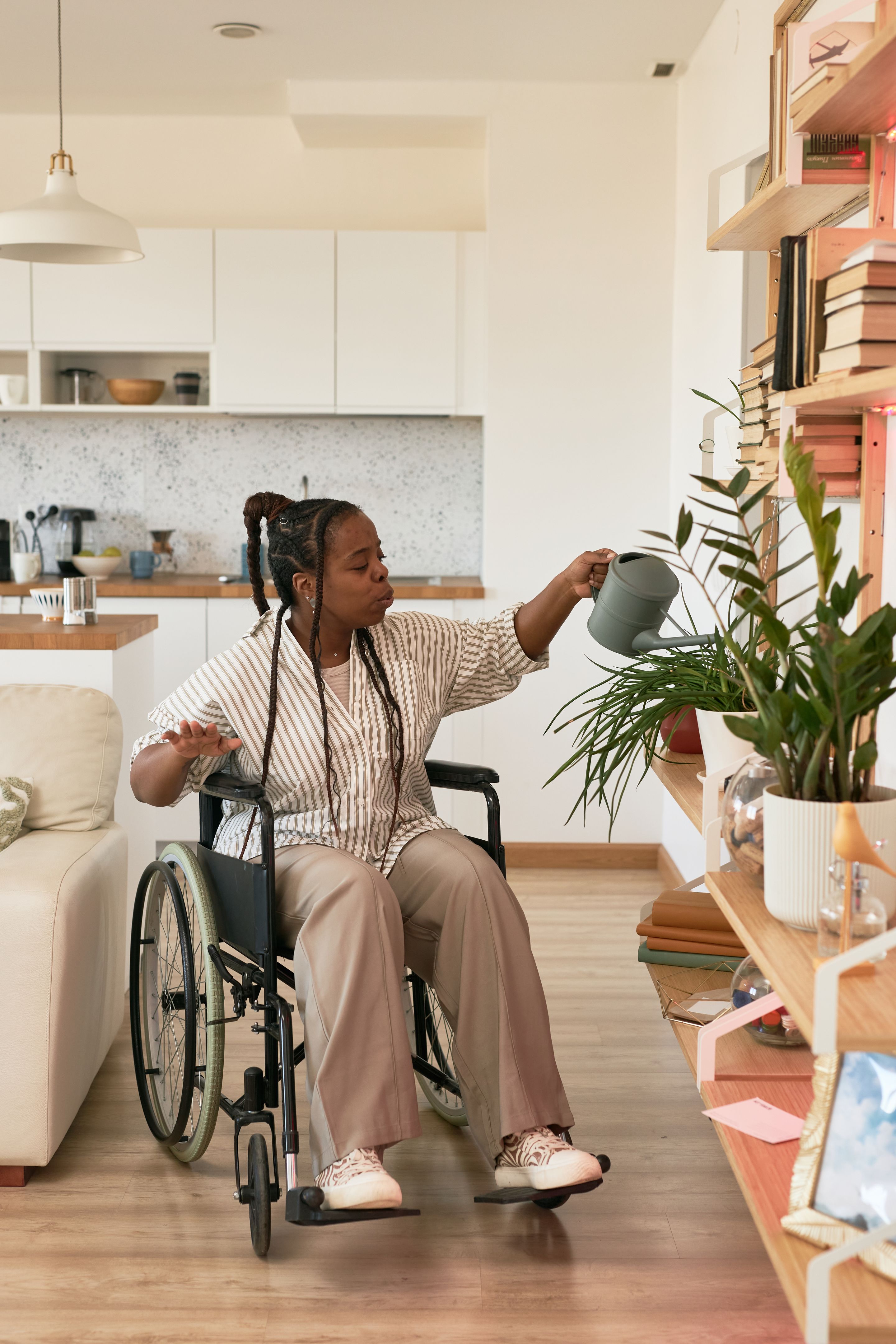 Watering Indoor Plant in Modern Home Kitchen Space