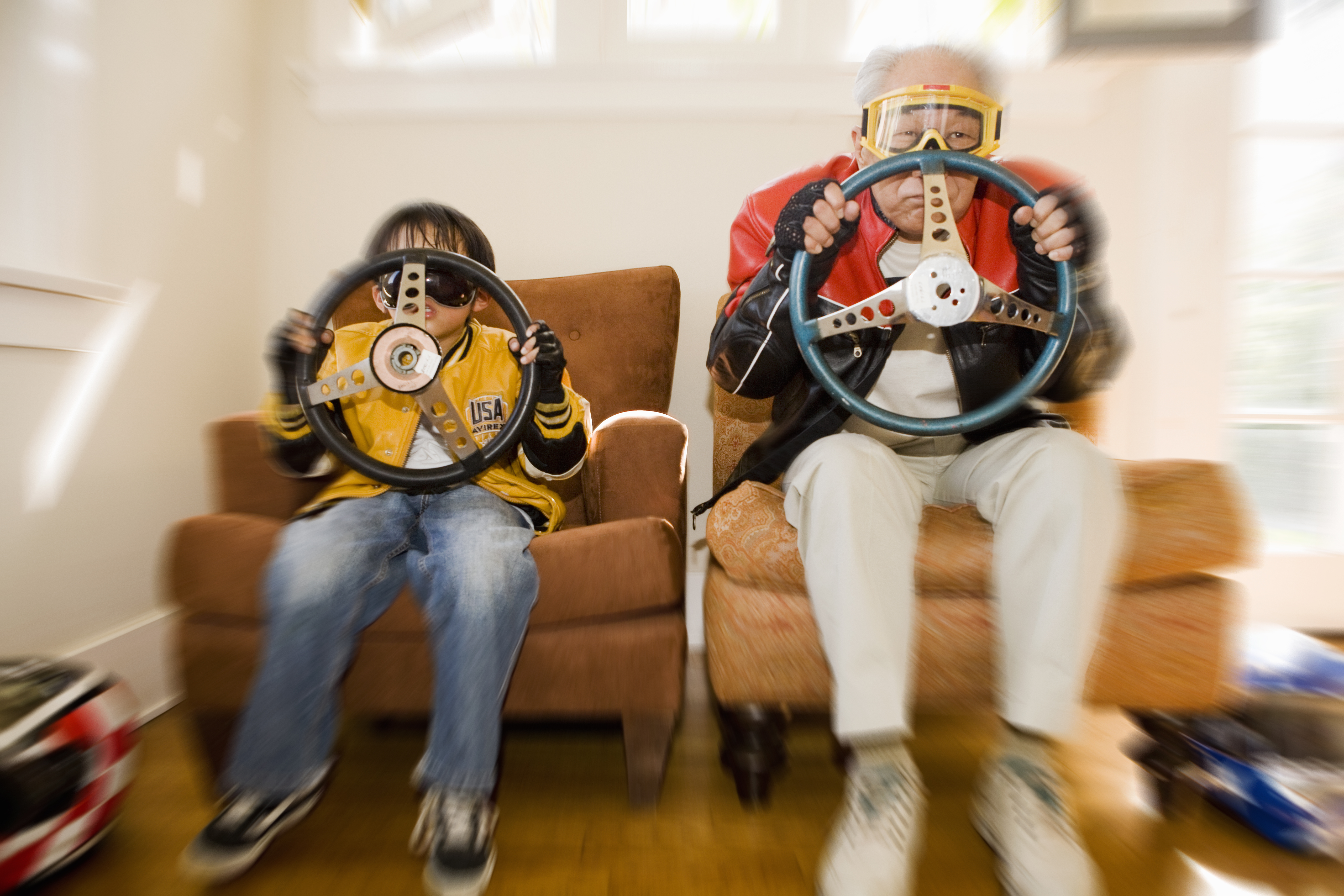 Boy and grandfather holding steering wheels