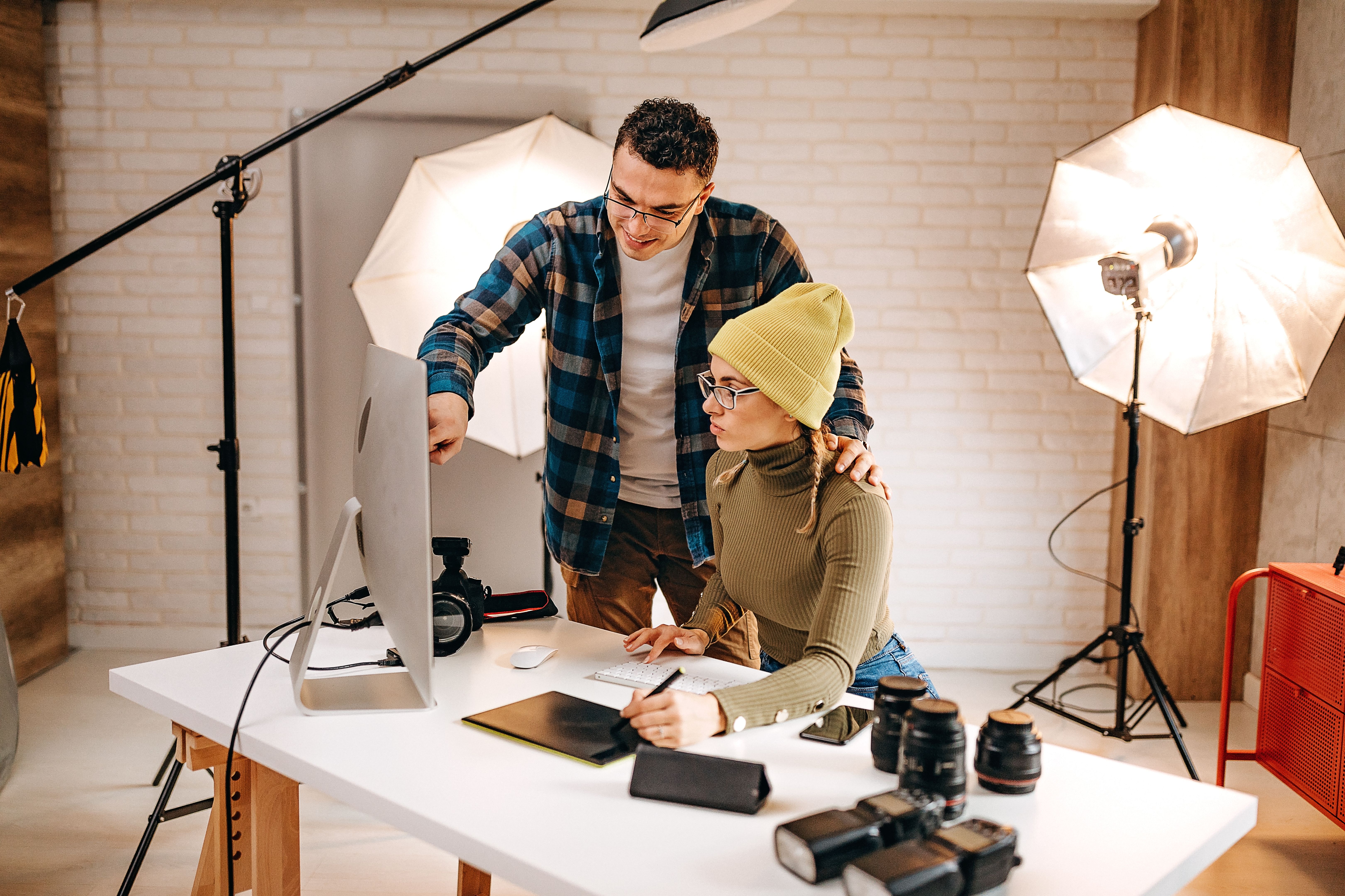 The model and the photographer look at the pictures on the computer after the session The model and the photographer look at the pictures on the computer after the session