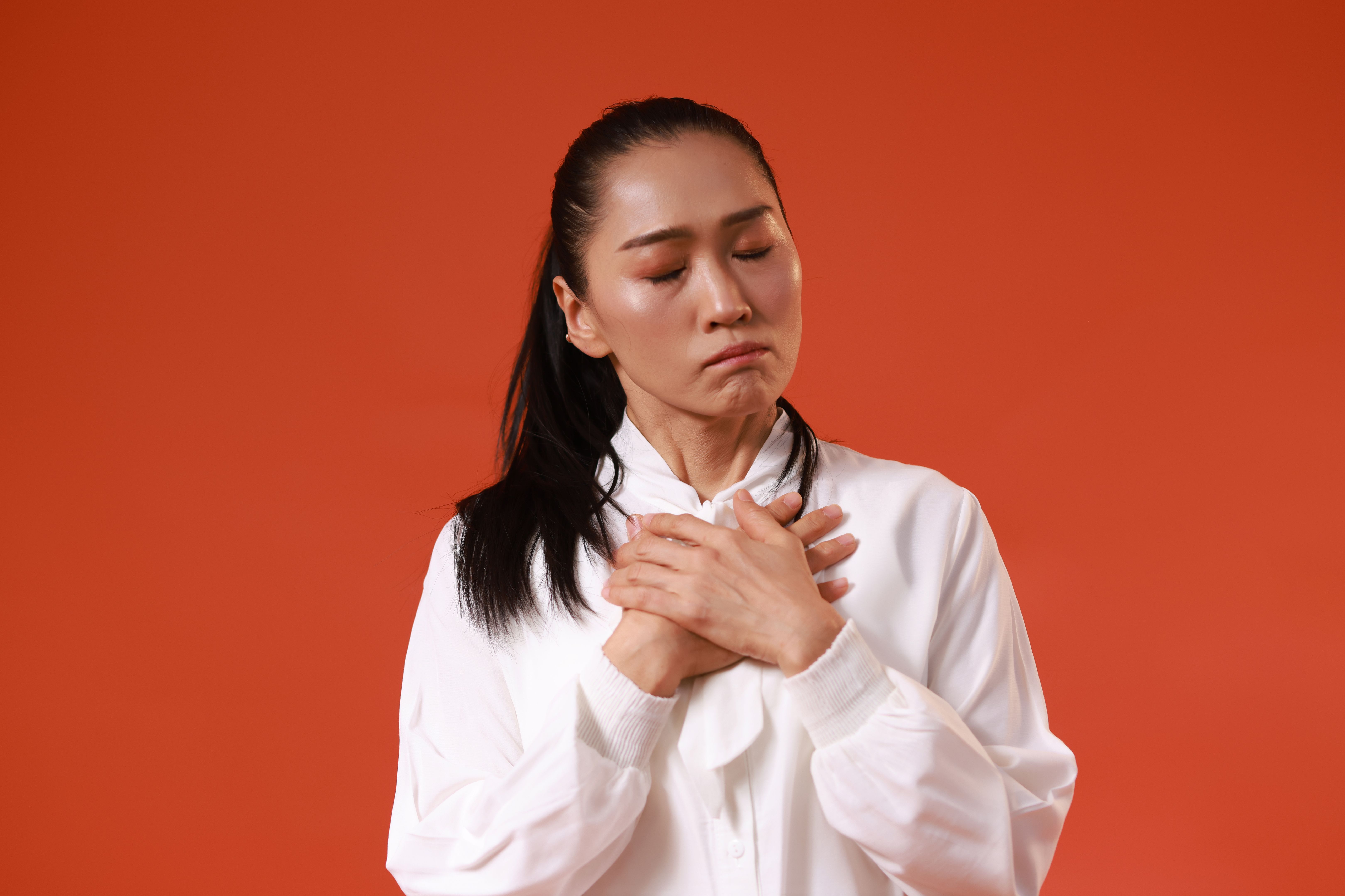 Portrait of serious or stressful woman copy space isolated over the red background Portrait of serious or stressful woman copy space isolated over the red background
