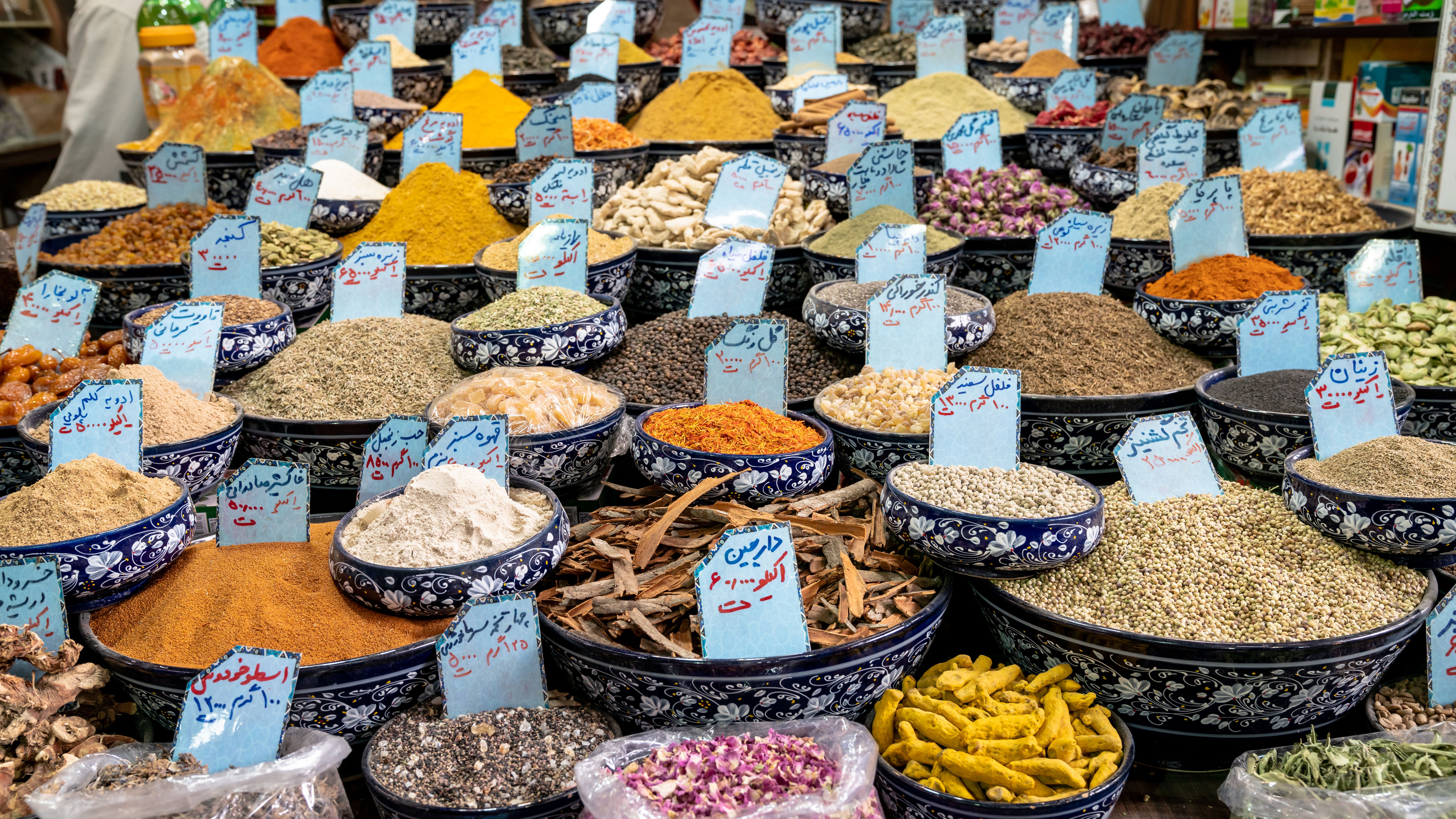 Piles of spices and herbs sold in a traditional Iranian market.