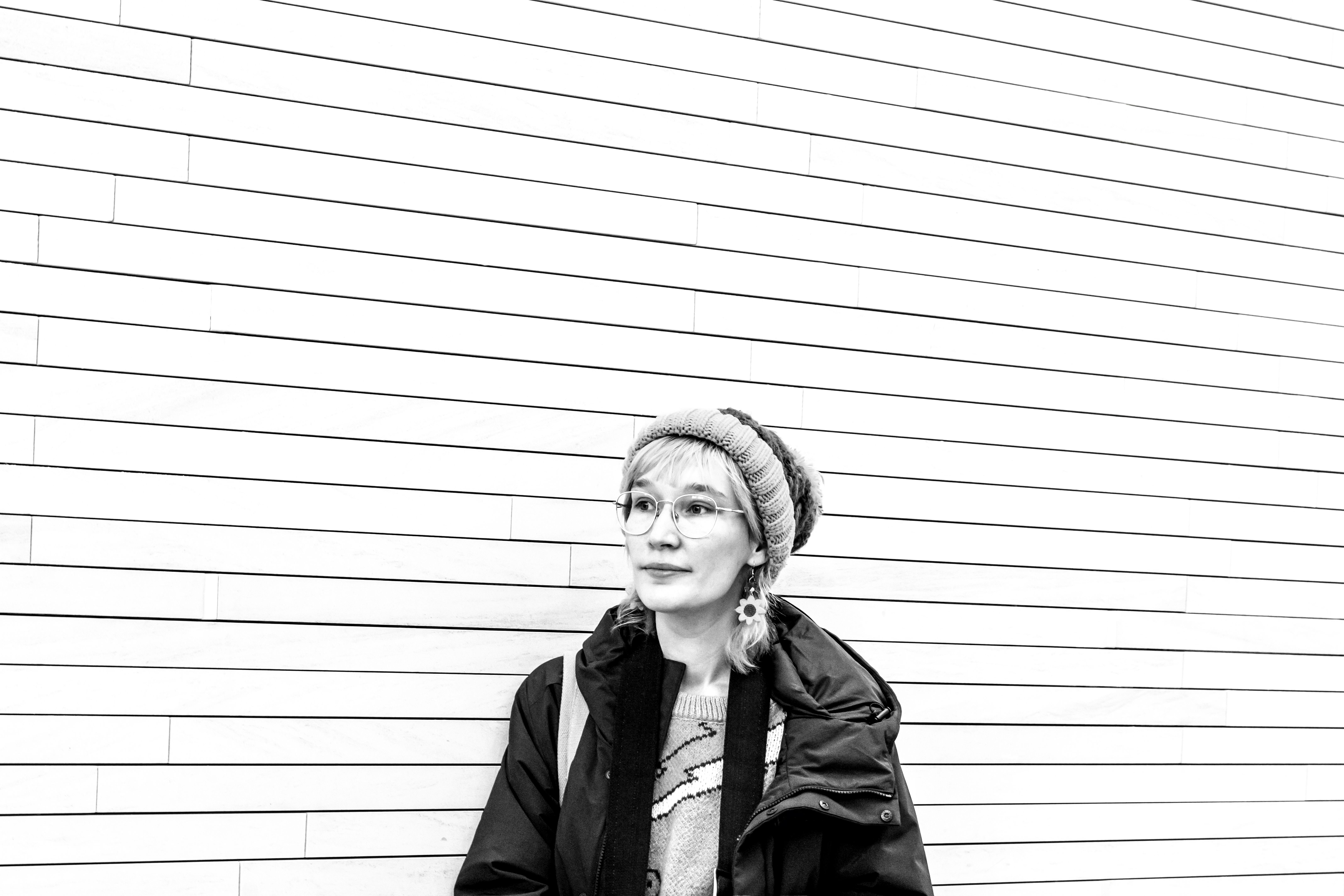 Black and white portrait of beautiful young woman with beanie, background with copy space