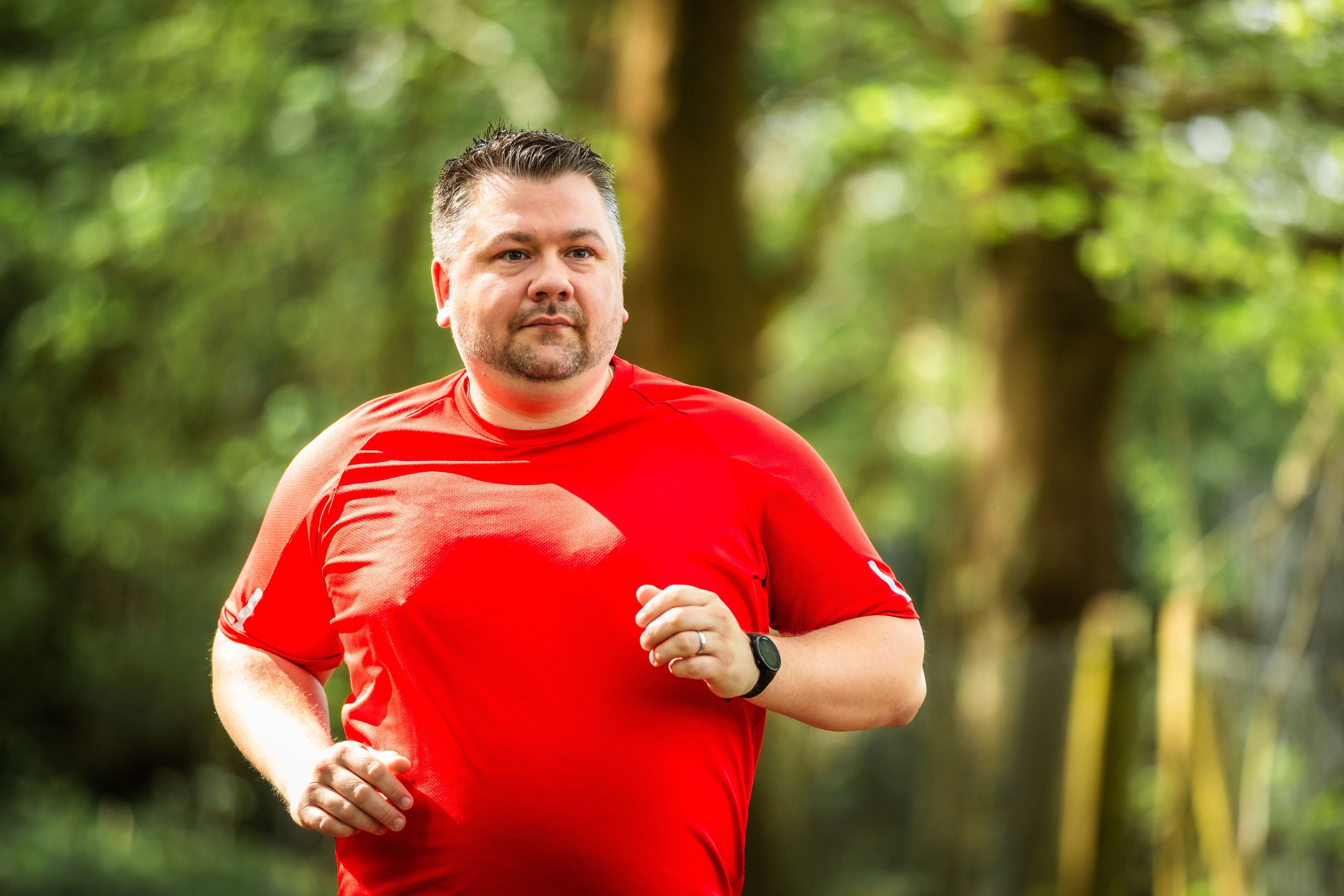 Mid adult man jogging on forest path