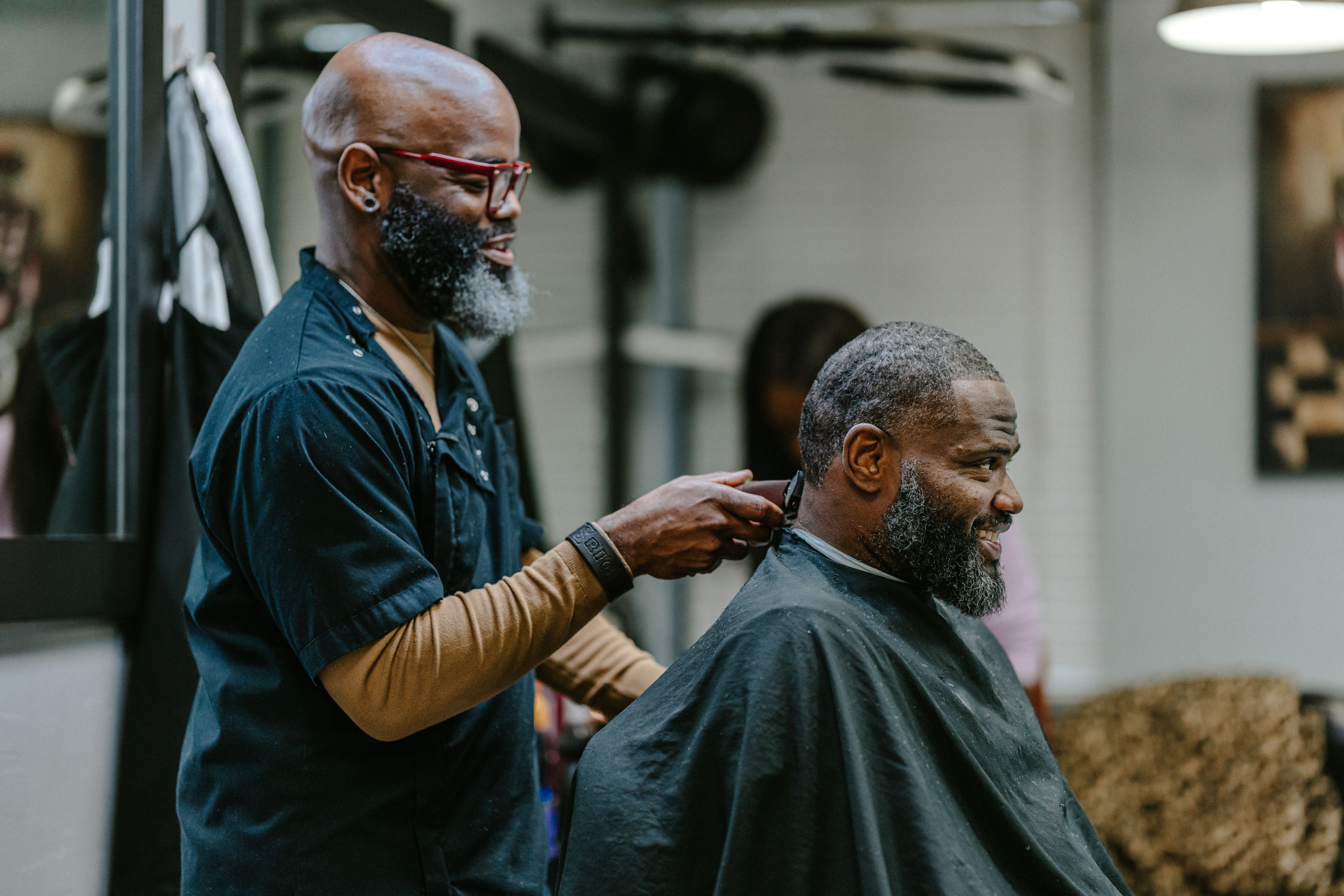 Barber cutting hair with electric razor