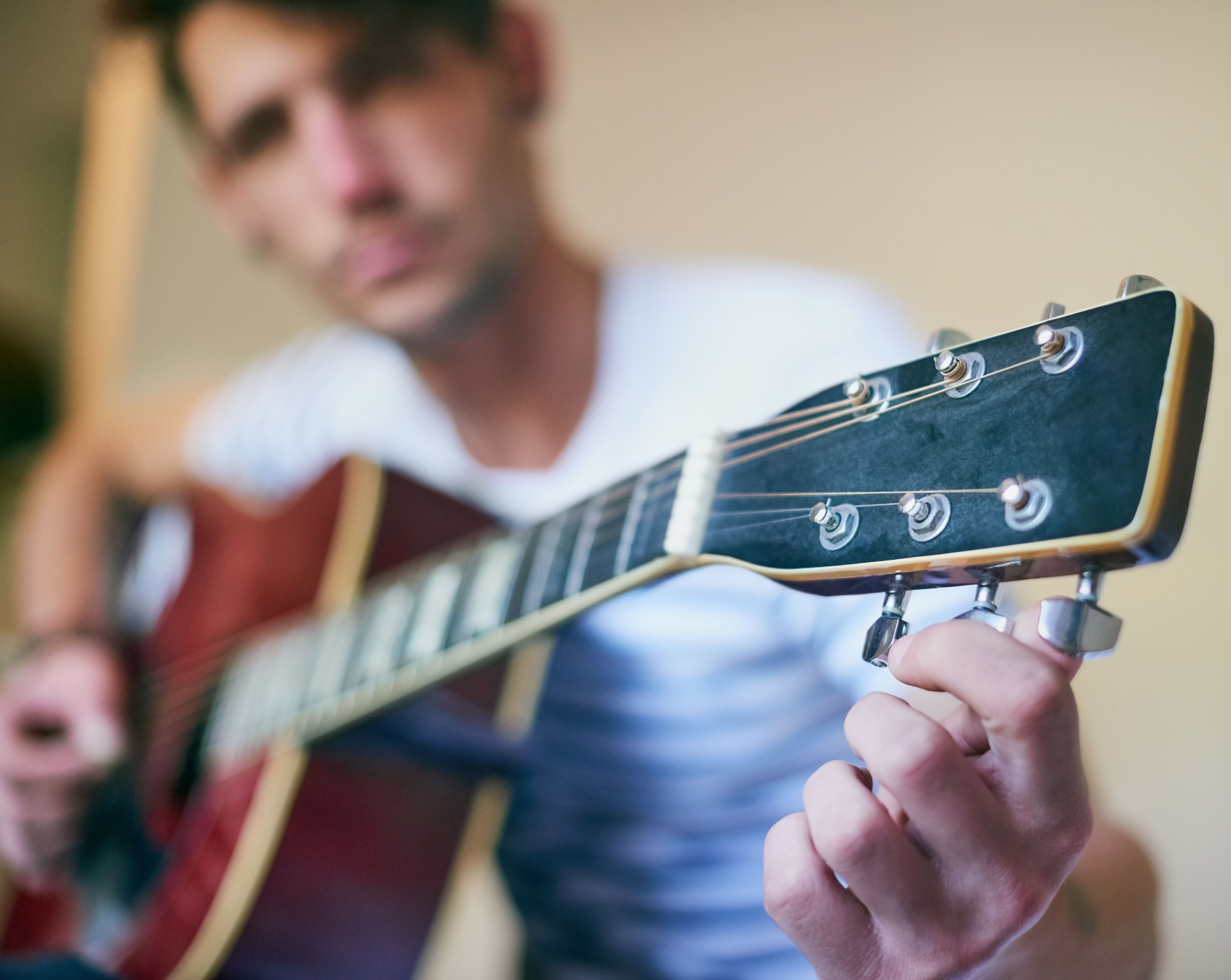 young adult practicing guitar