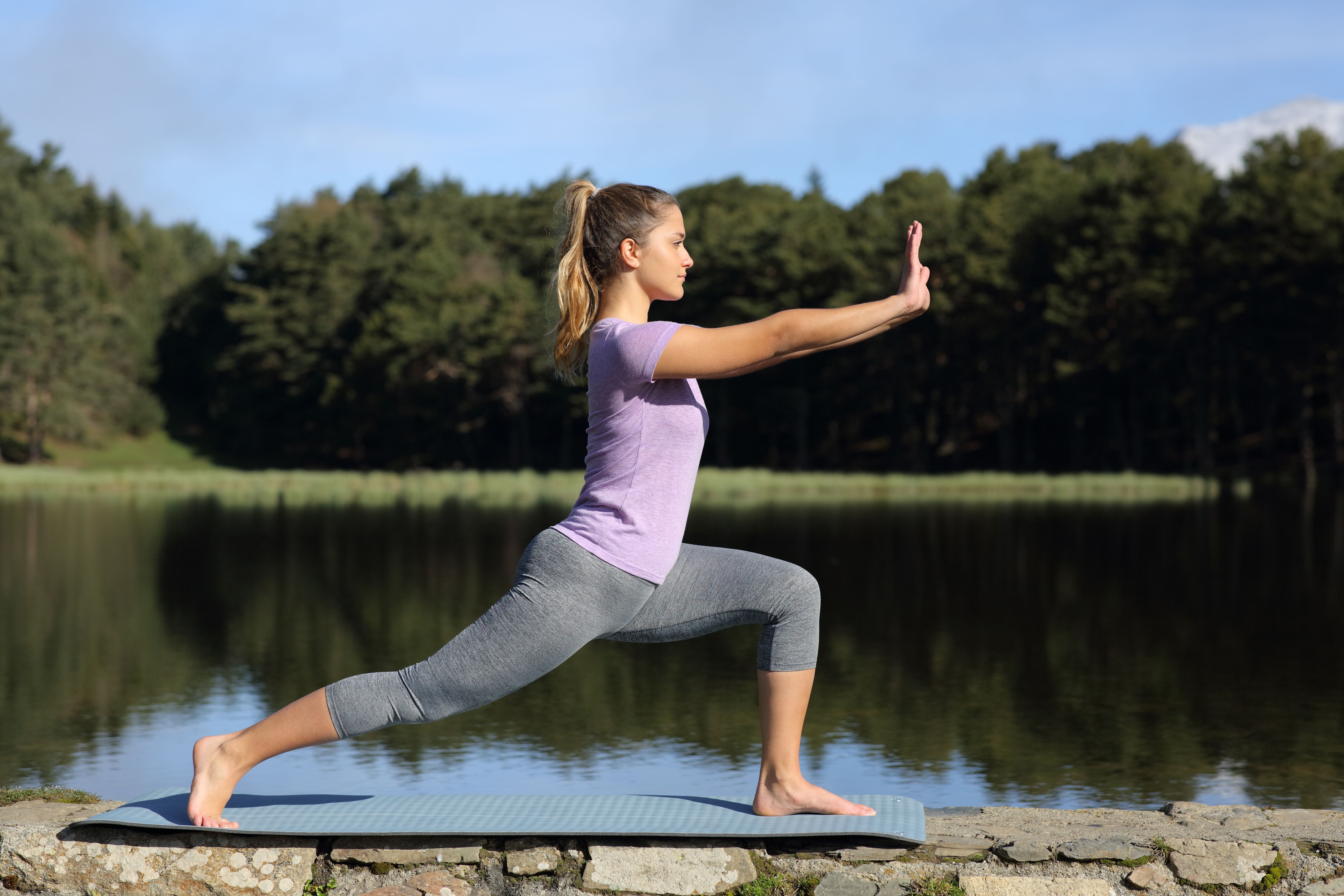 Woman practicing tai chi pose in a lake Woman practicing tai chi pose in a lake