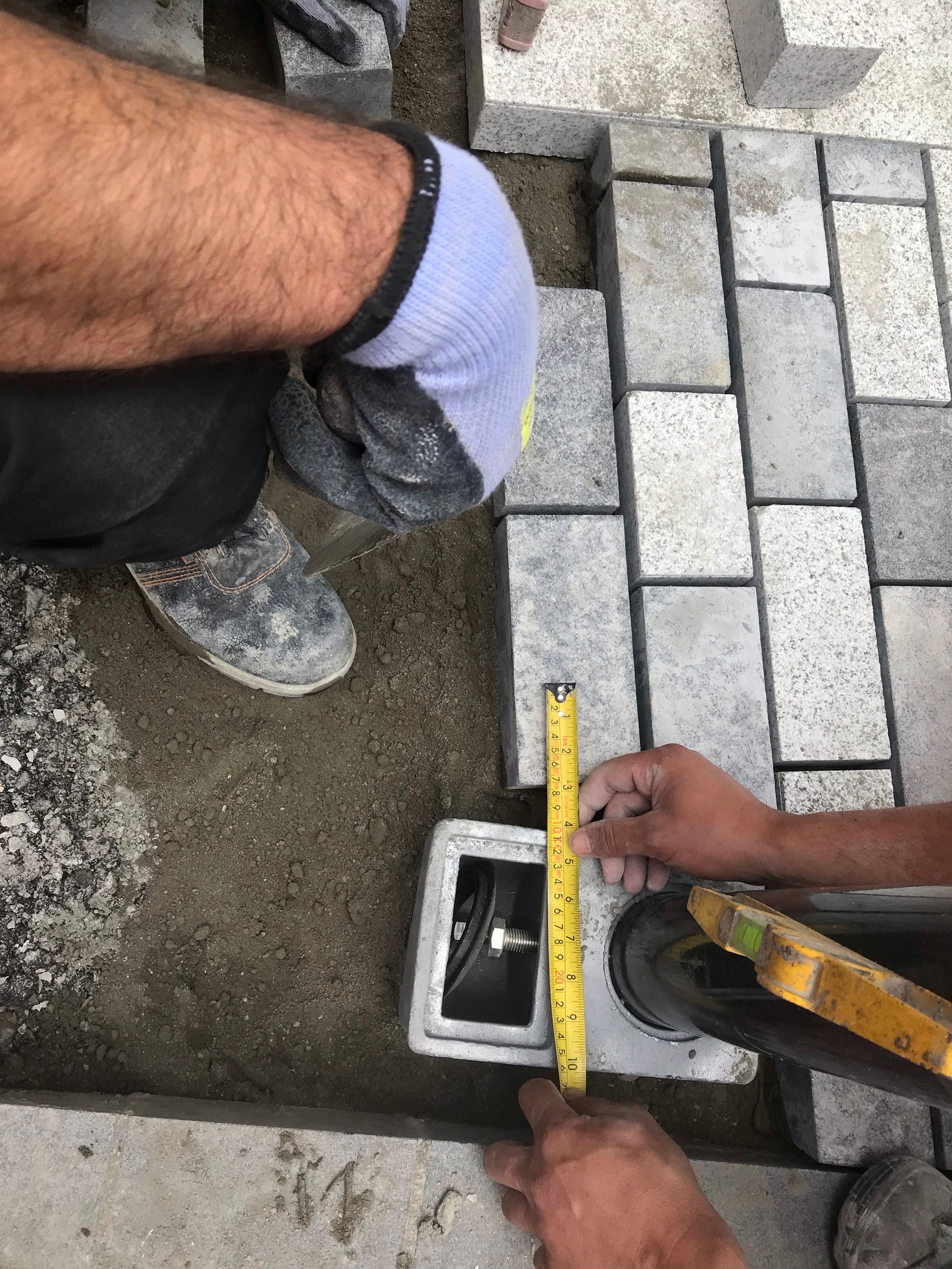 Workers measure tiles on the ground. Workers measure tiles on the ground.