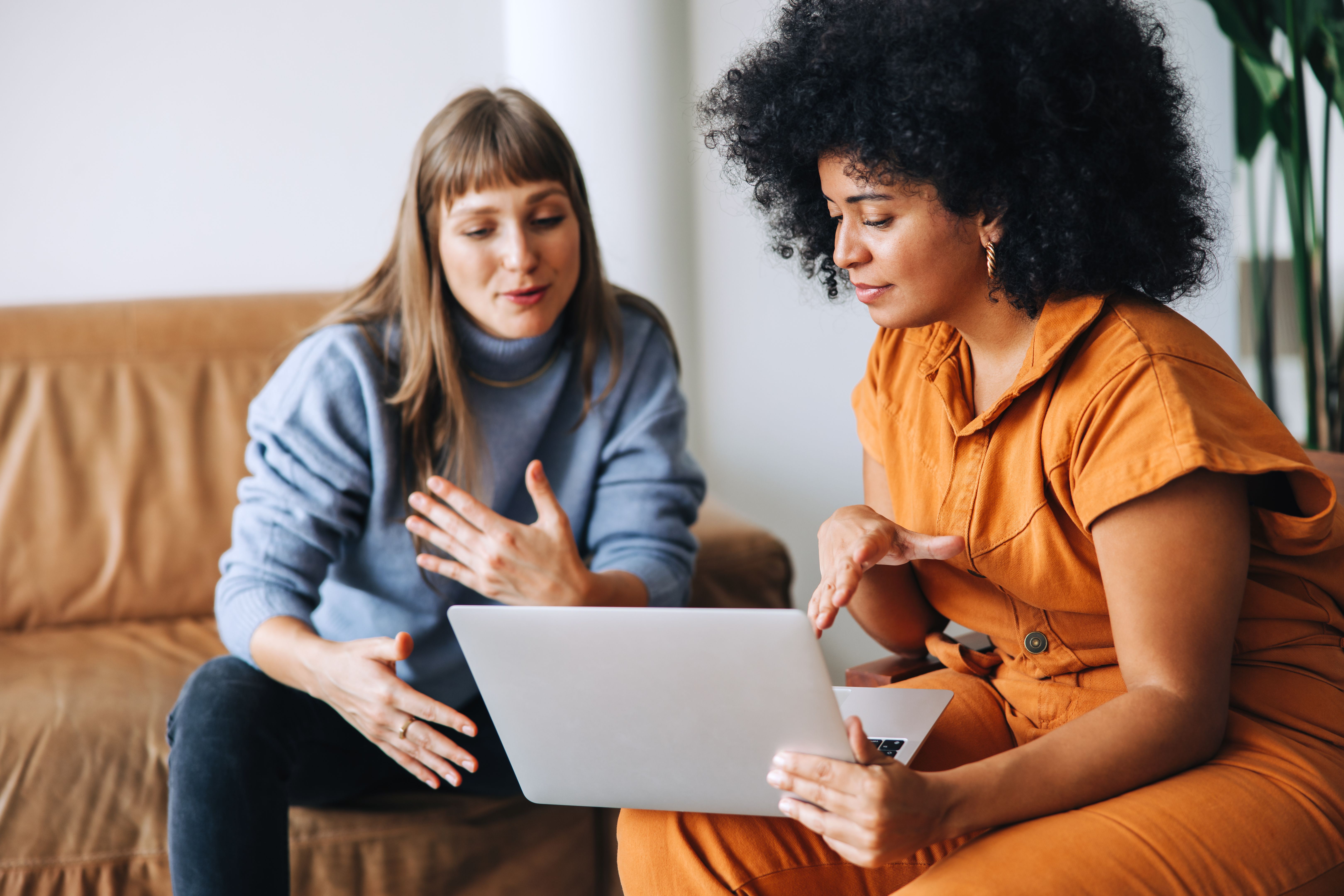Two businesswomen having a discussion while looking at a laptop screen Two businesswomen having a discussion while looking at a laptop screen