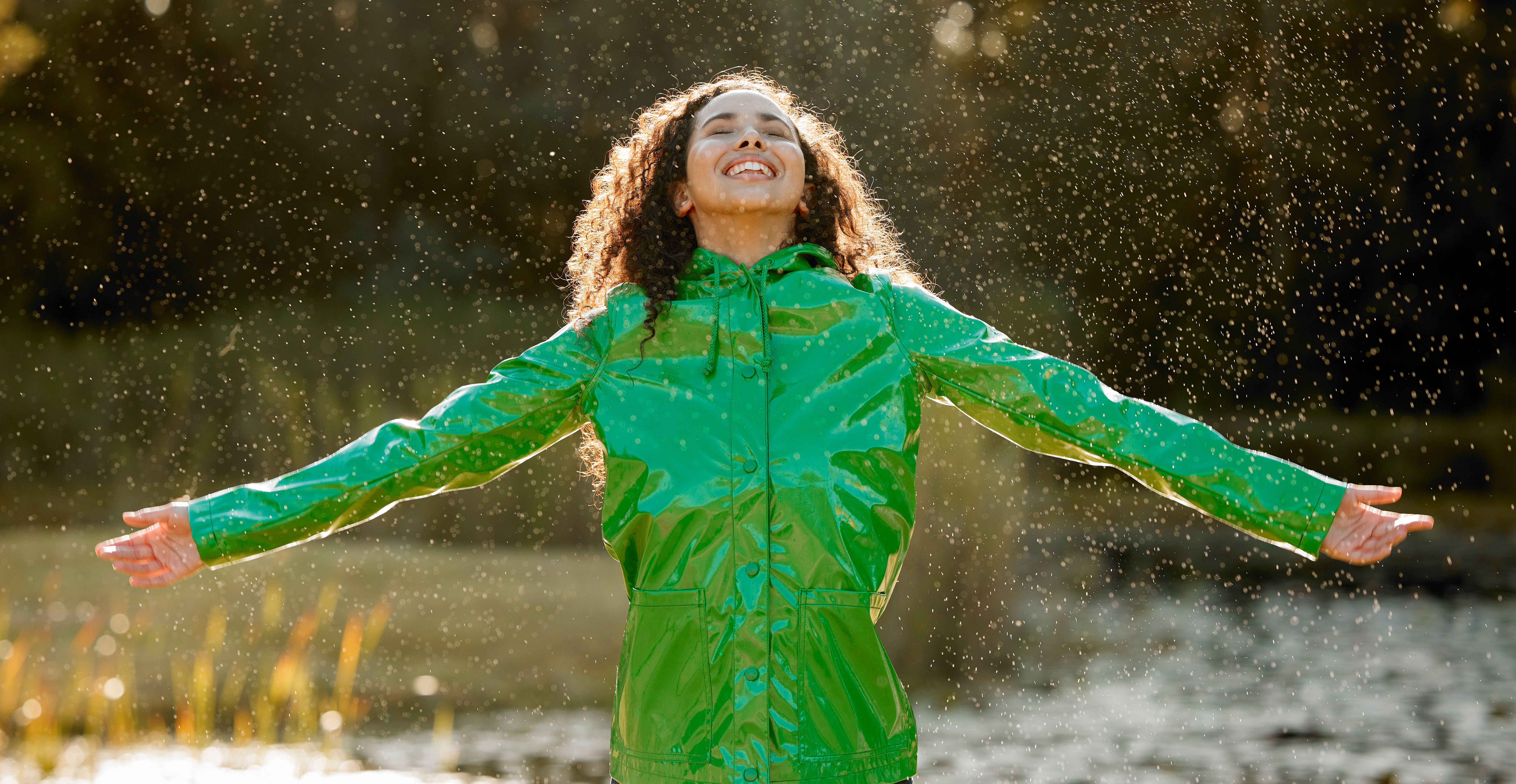 Shot of a beautiful young woman having fun in the rain Shot of a beautiful young woman having fun in the rain