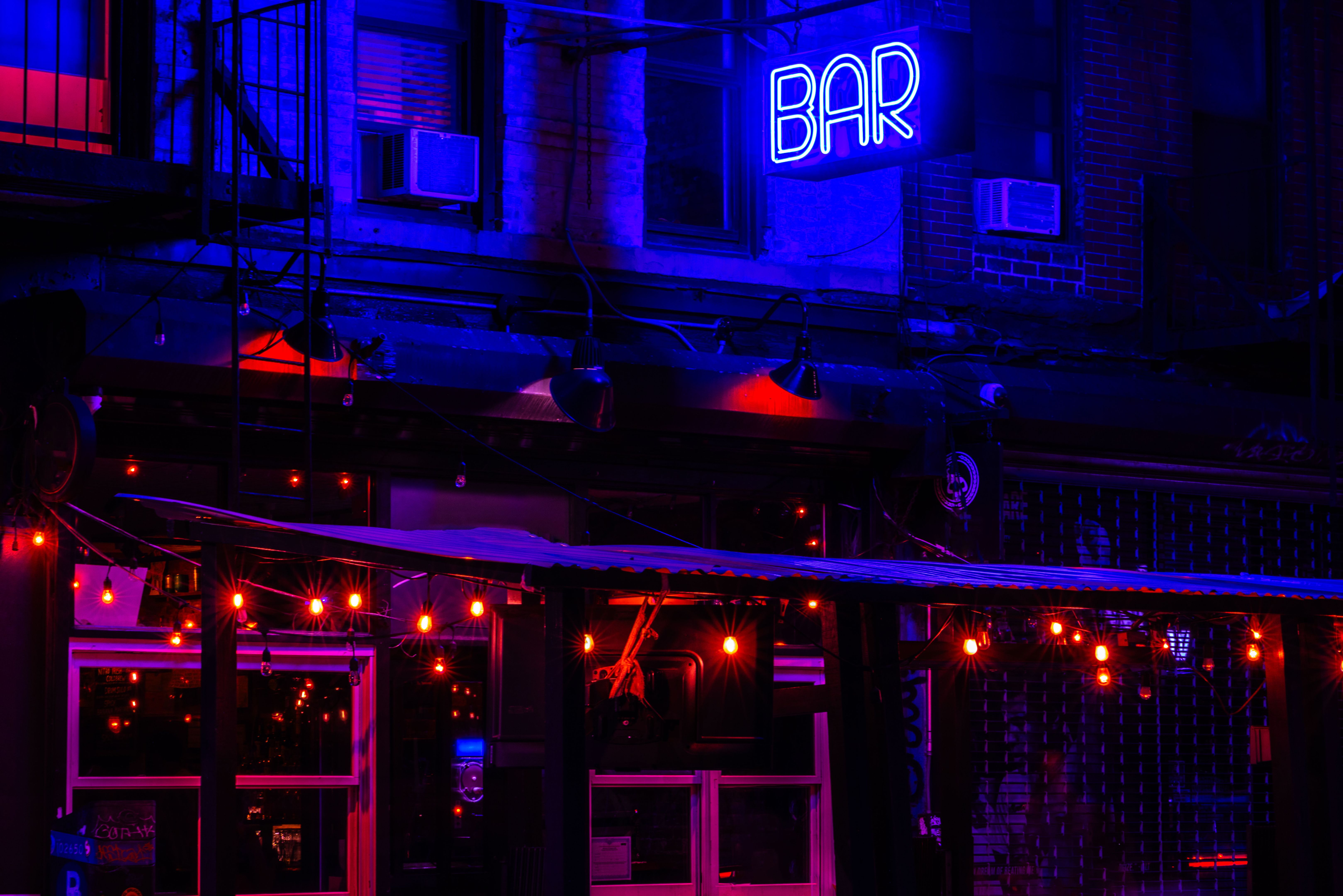 Neon Blue "Bar" Sign Contrasted With Red Hanging Lights