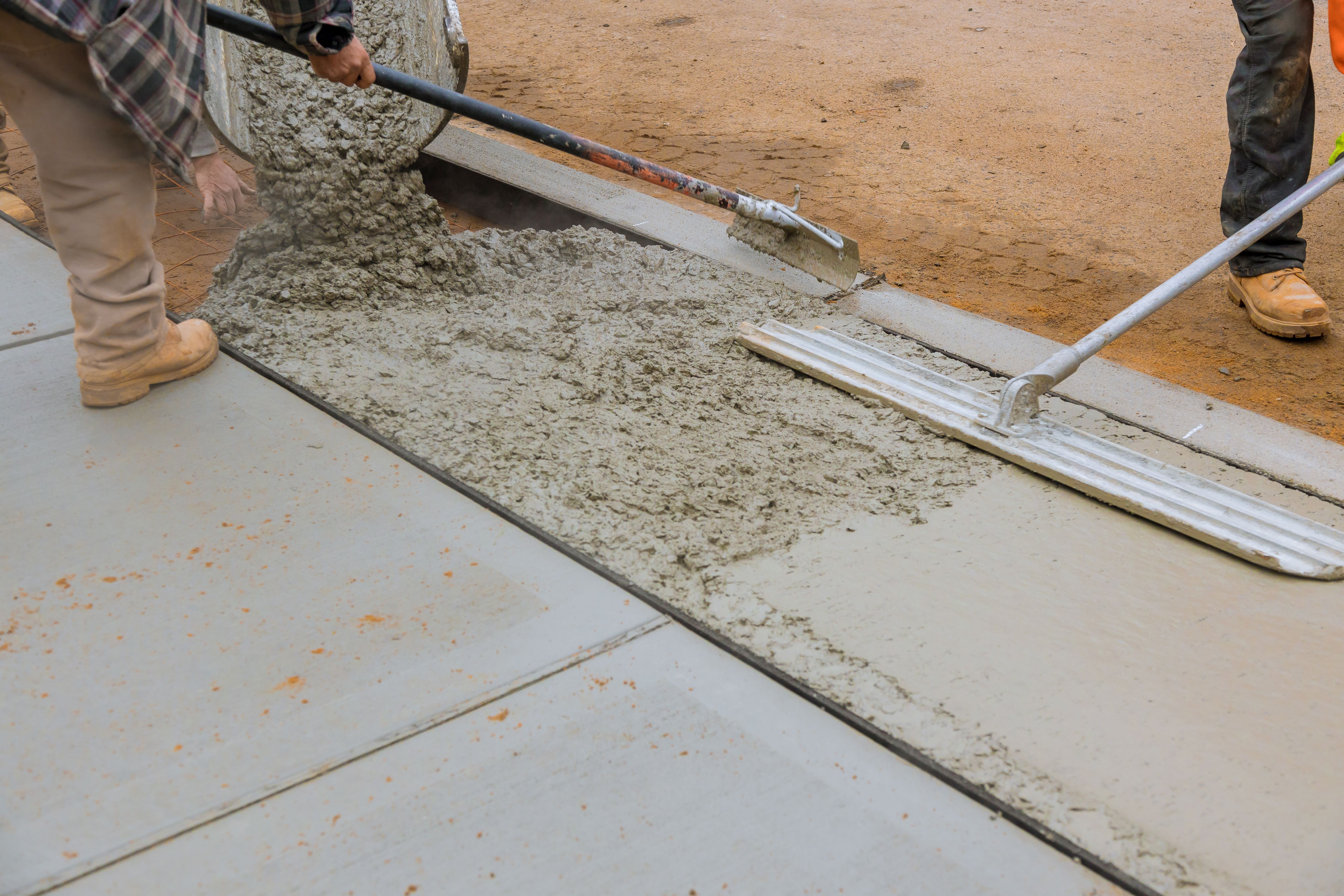Construction of a concrete walkway around a residential rural house in manual of the pavement