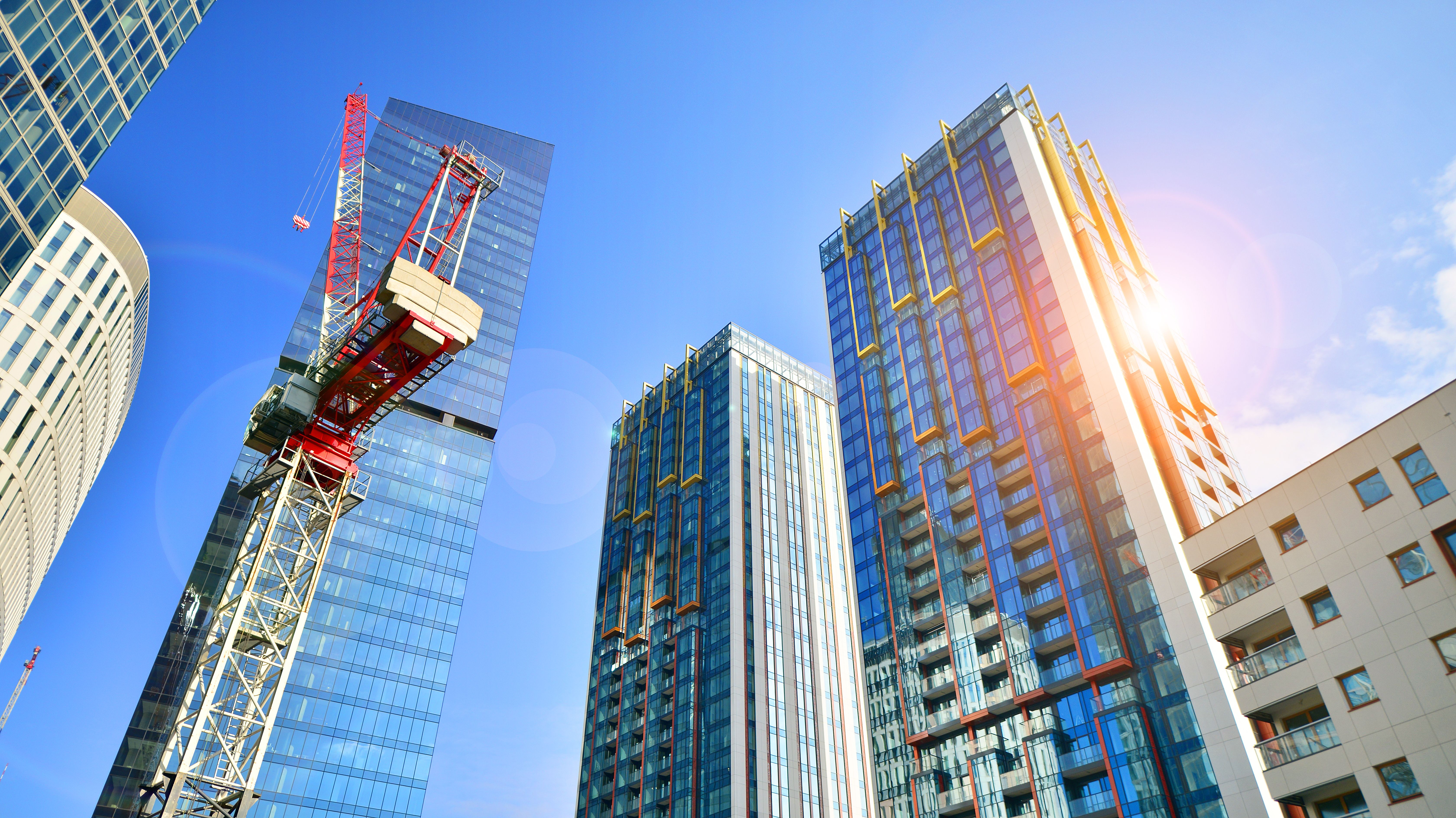 Crane on the construction site in a site surrounded by the high buildings.