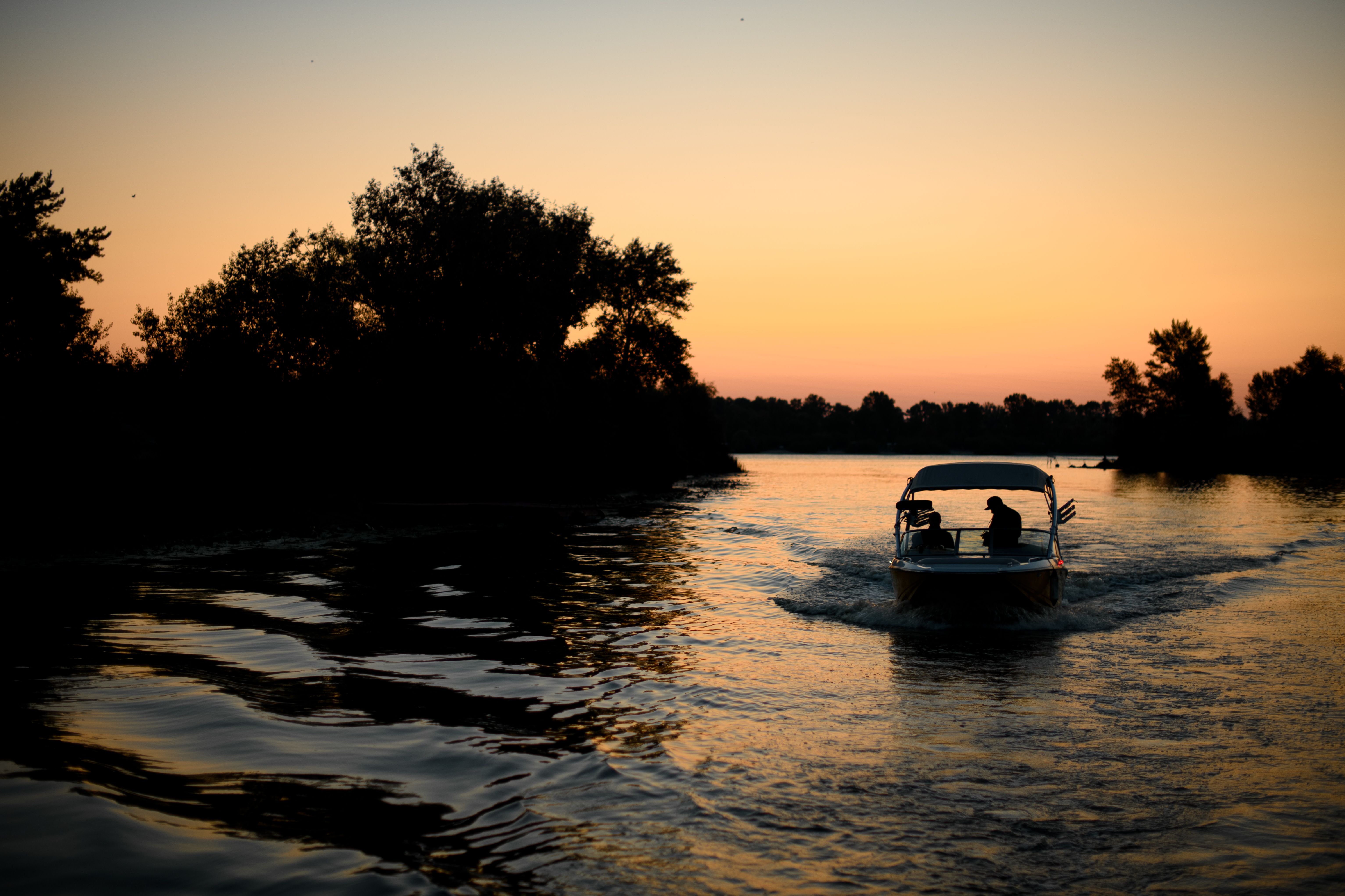 Magnificent evening view of the river along which the motor boat is sailing