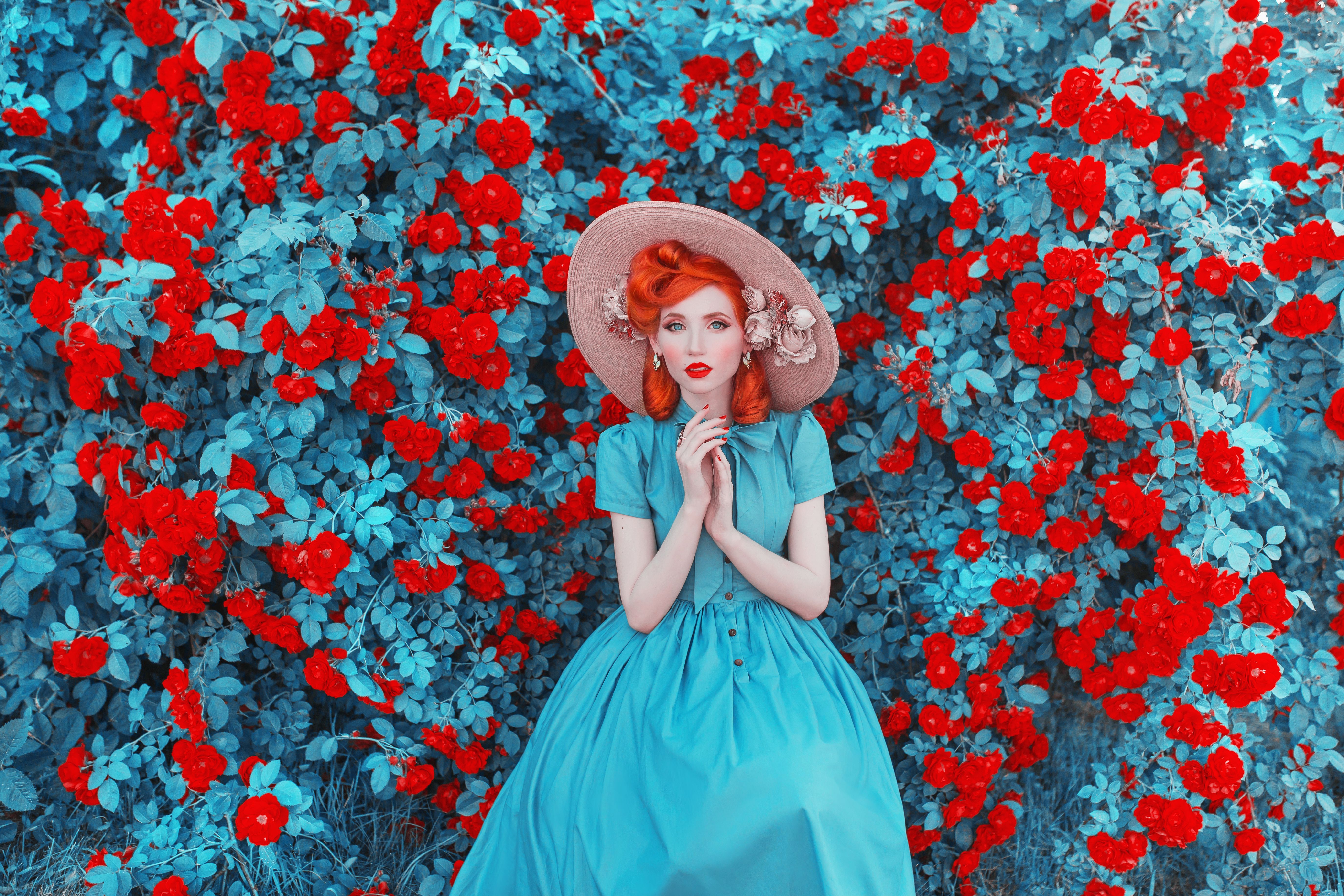 Valentines Day background. Spring rose flower garden. Fabulous lady with red lips in dress. Gardening on farm. Awesome flower wall. Redhead lady on fabulous background of rose garden. Spring gardening