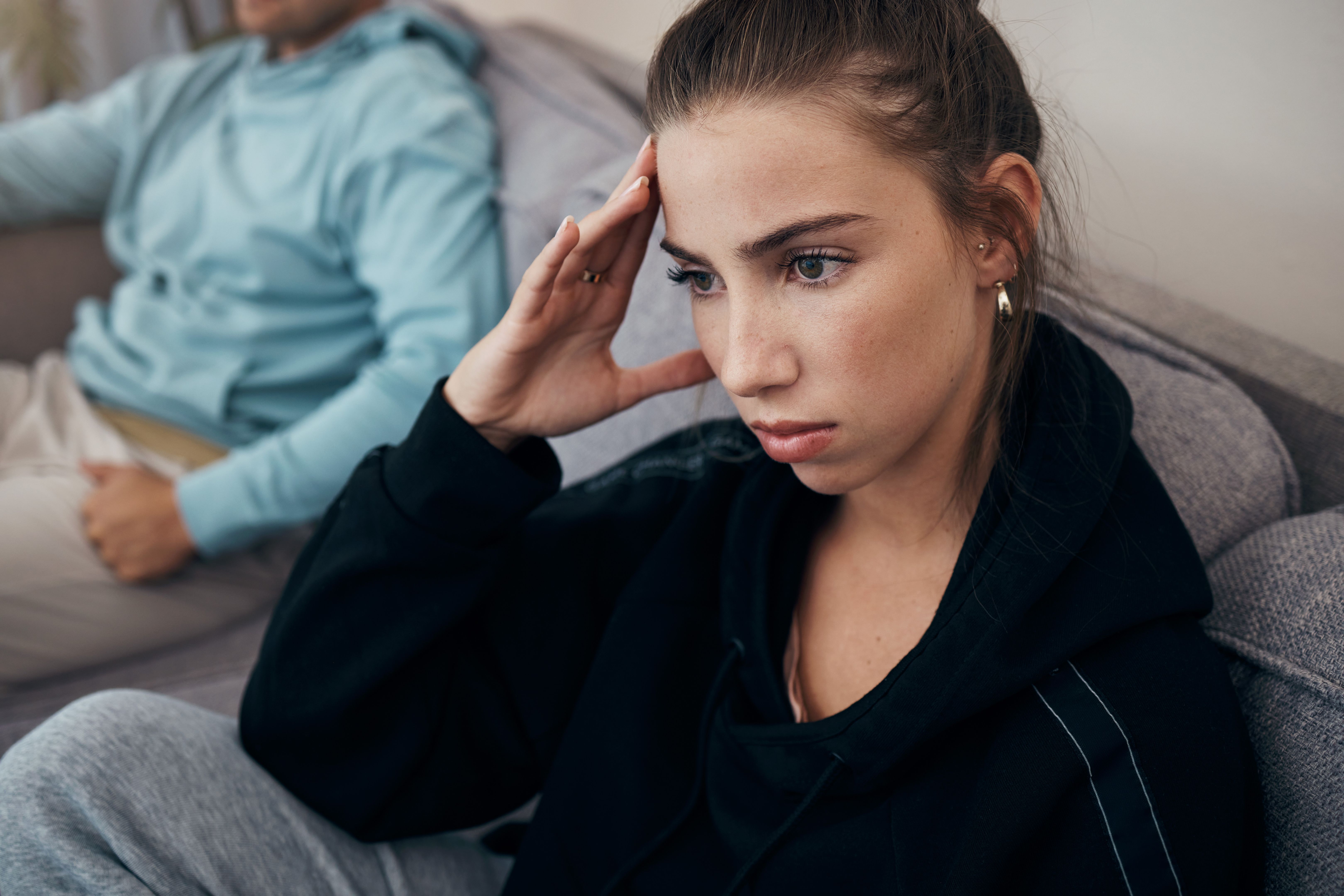 Divorce, stress and angry couple on a sofa after fighting, argue or infertility problem at home. Marriage, conflict and frustrated woman in living room overthinking, anxiety or sad with cheating man