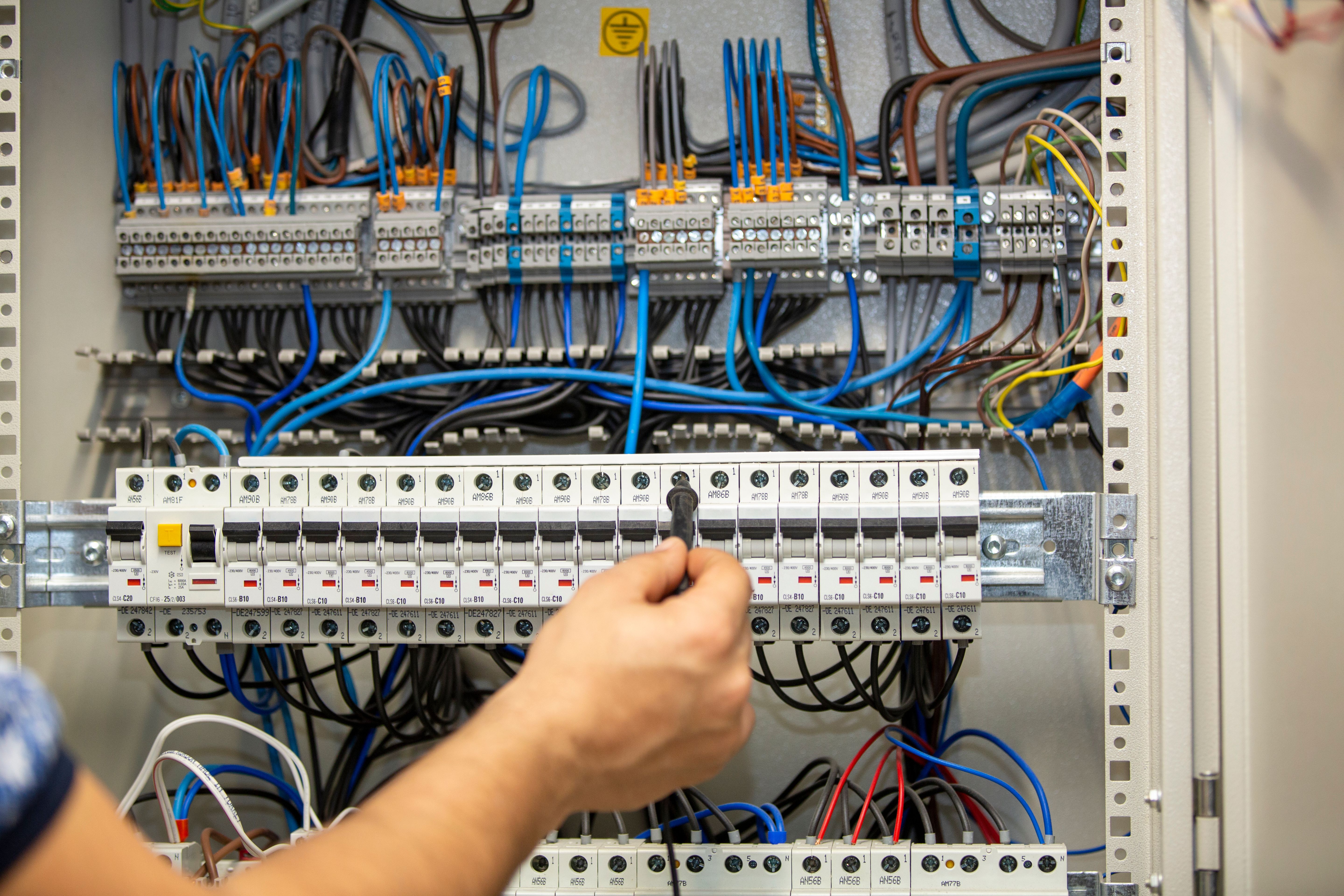 Electrician working at electric panel