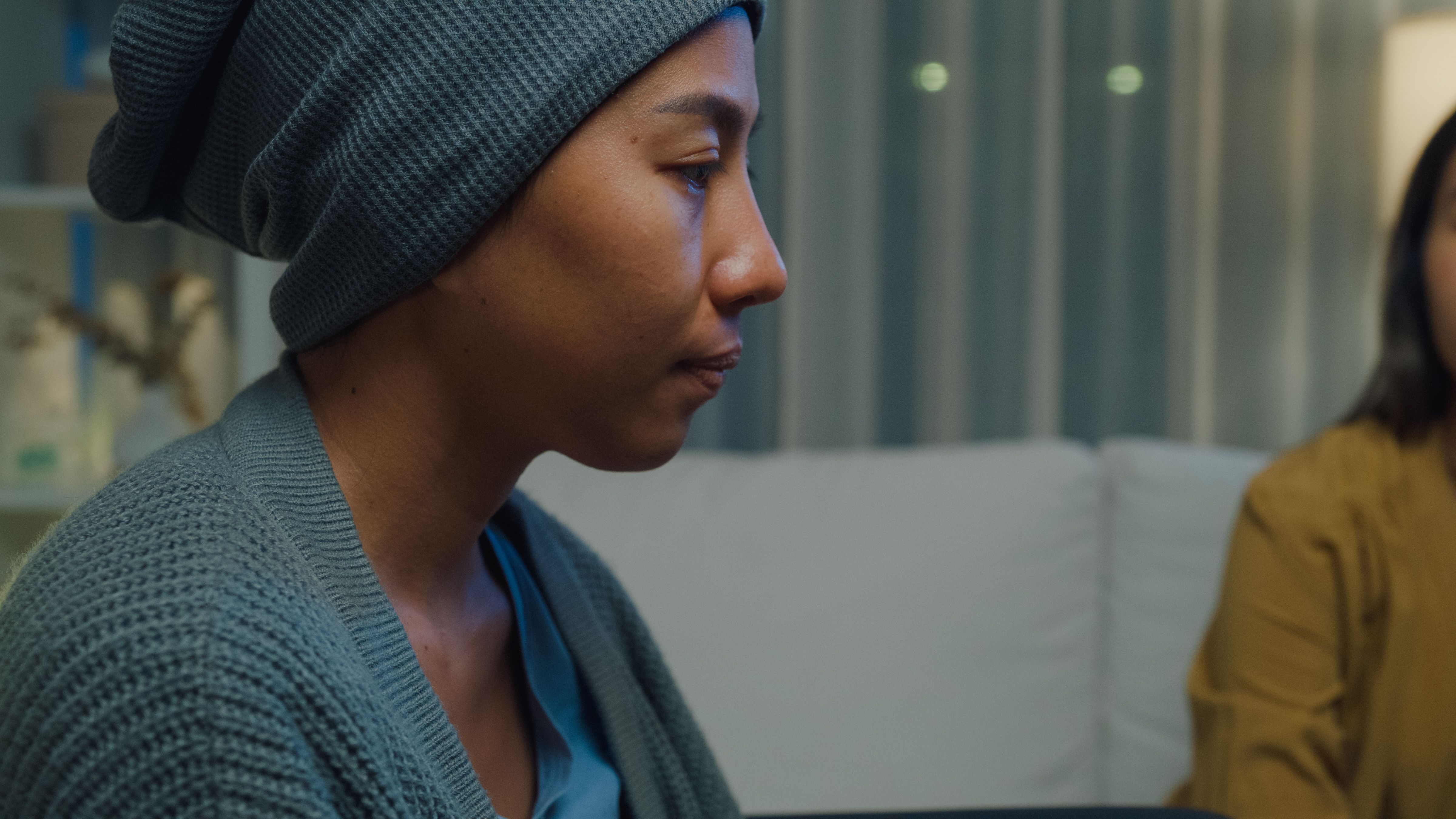 Young Asian people holding hands trust comfort help cancer patients talk crying stress relief in living room at home at night. Healthcare.