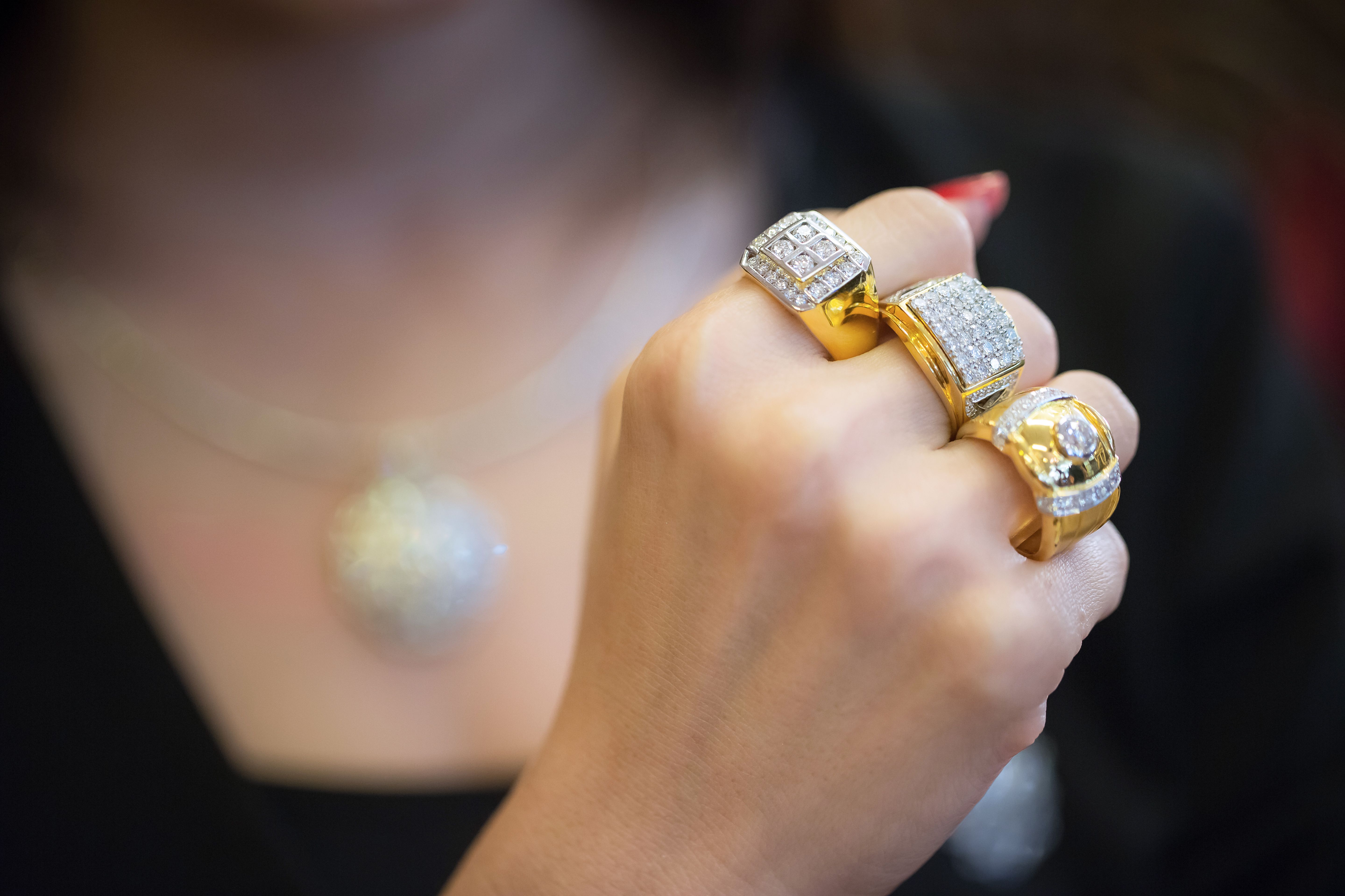Young woman hands with multiple bracelets and fingers with many rings with diamond
