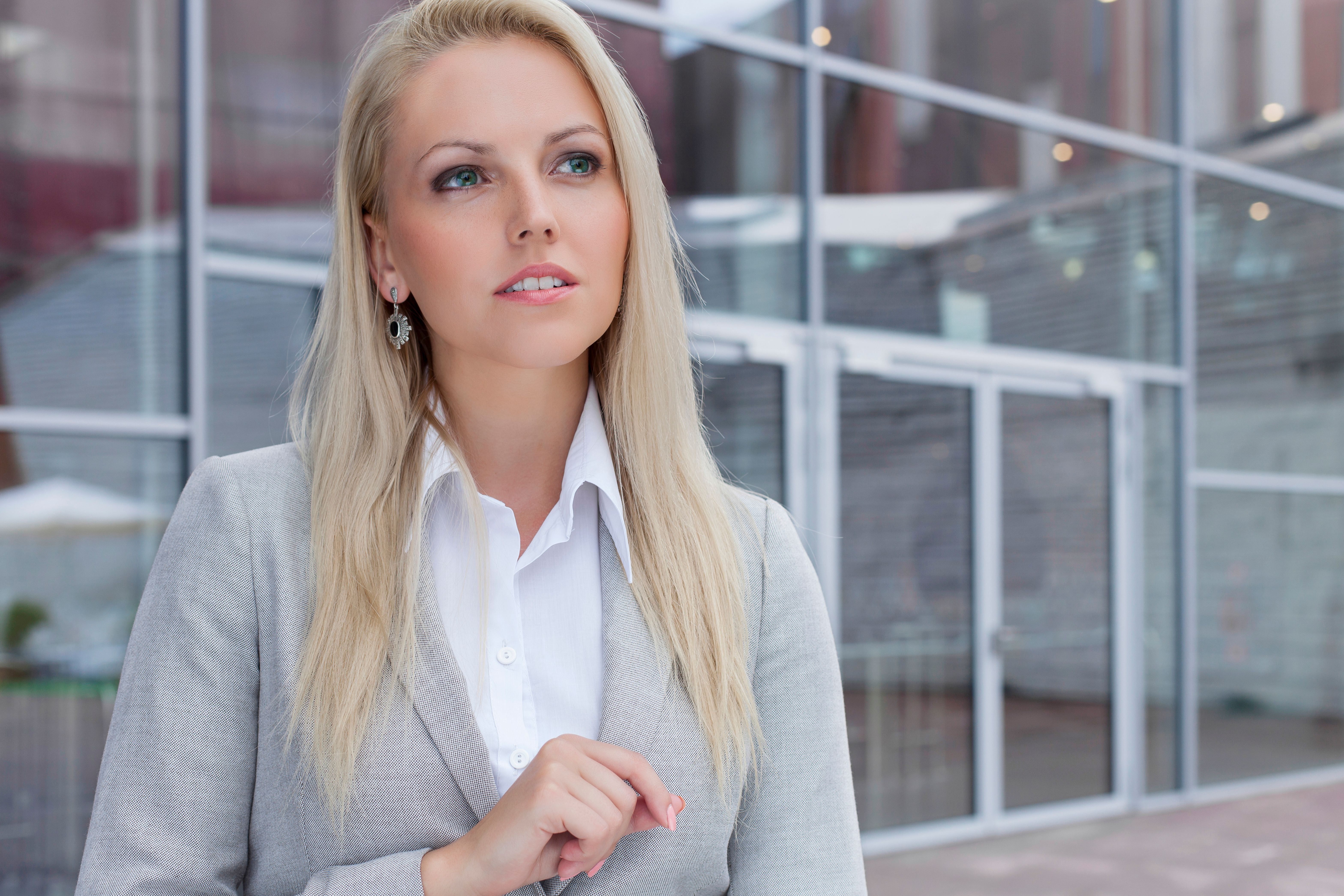Thoughtful businesswoman looking away against office building Thoughtful businesswoman looking away against office building