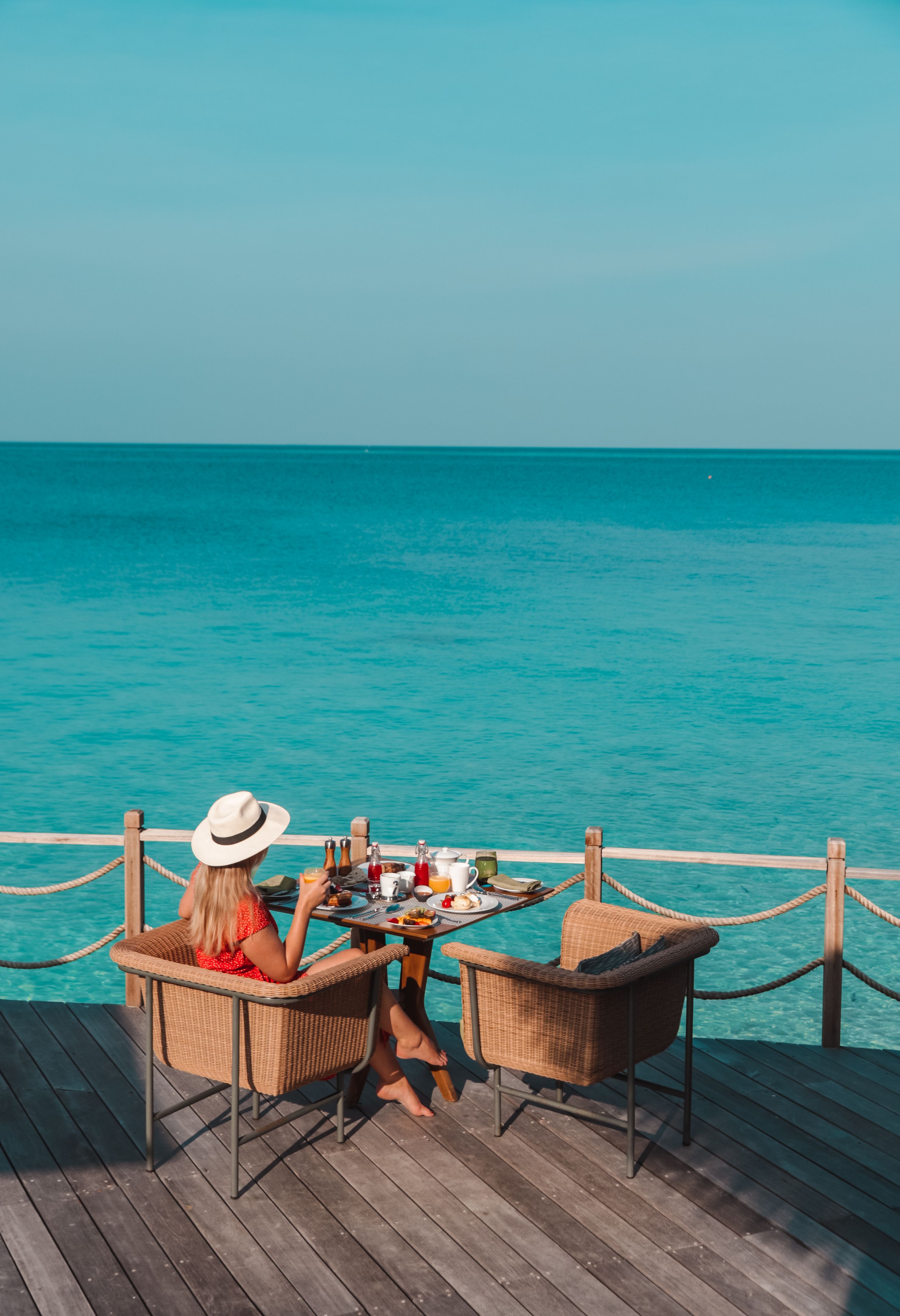 Woman having breakfast by the sea in Maldives Woman having breakfast by the sea in Maldives