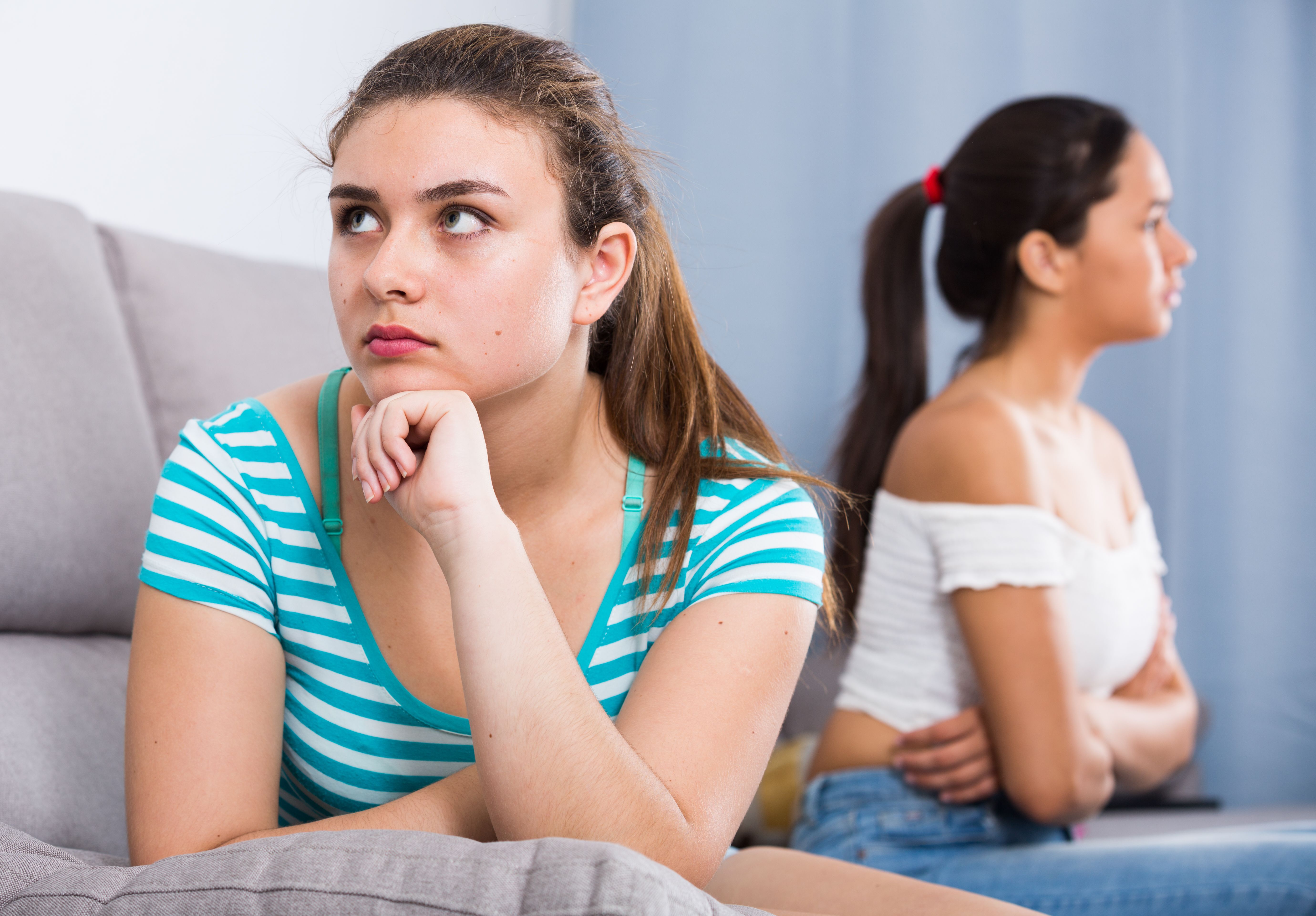 Quarreled girls apart on couch