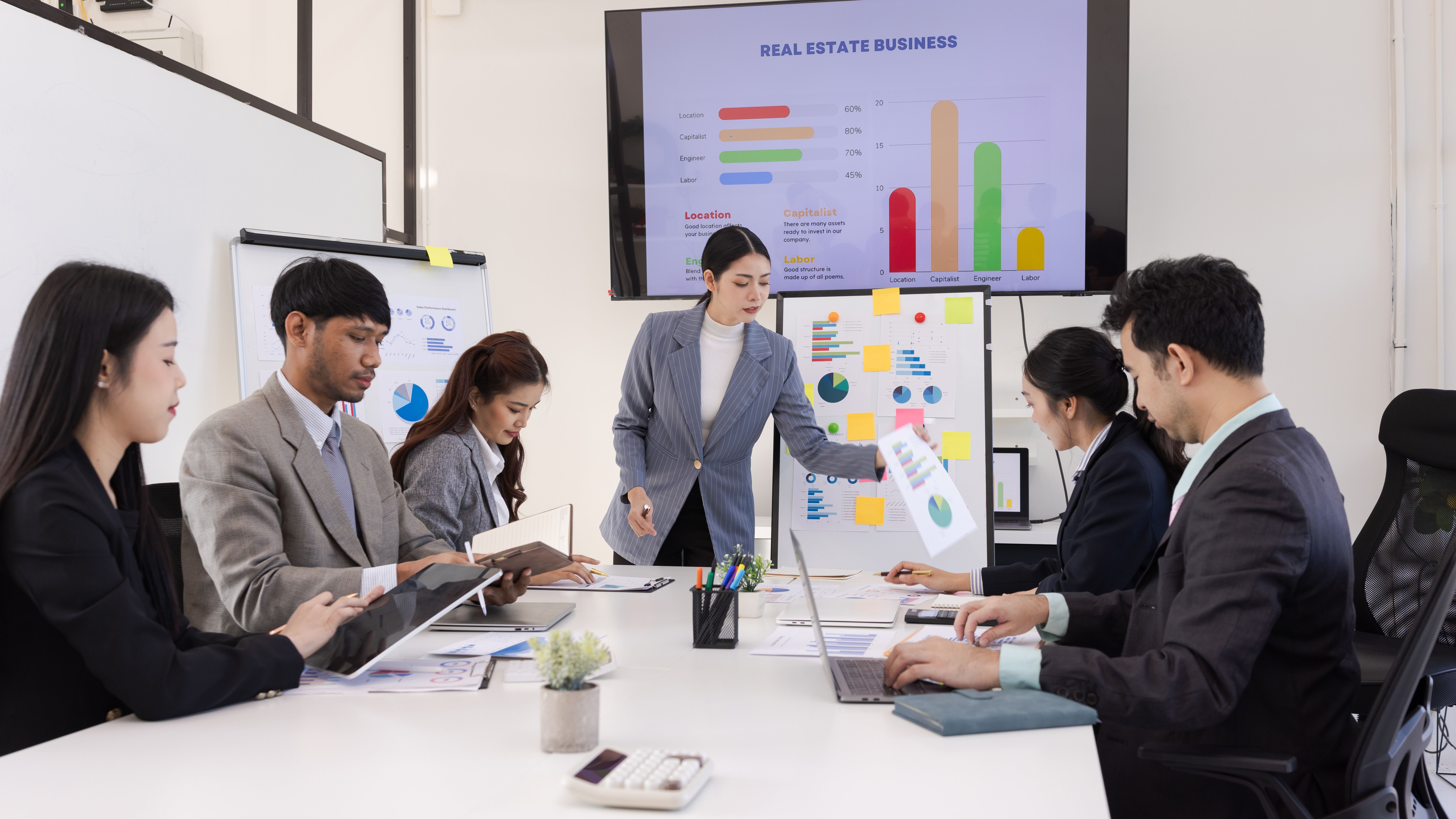 Group of business people working together with dashboard analysis and data management in meeting room.