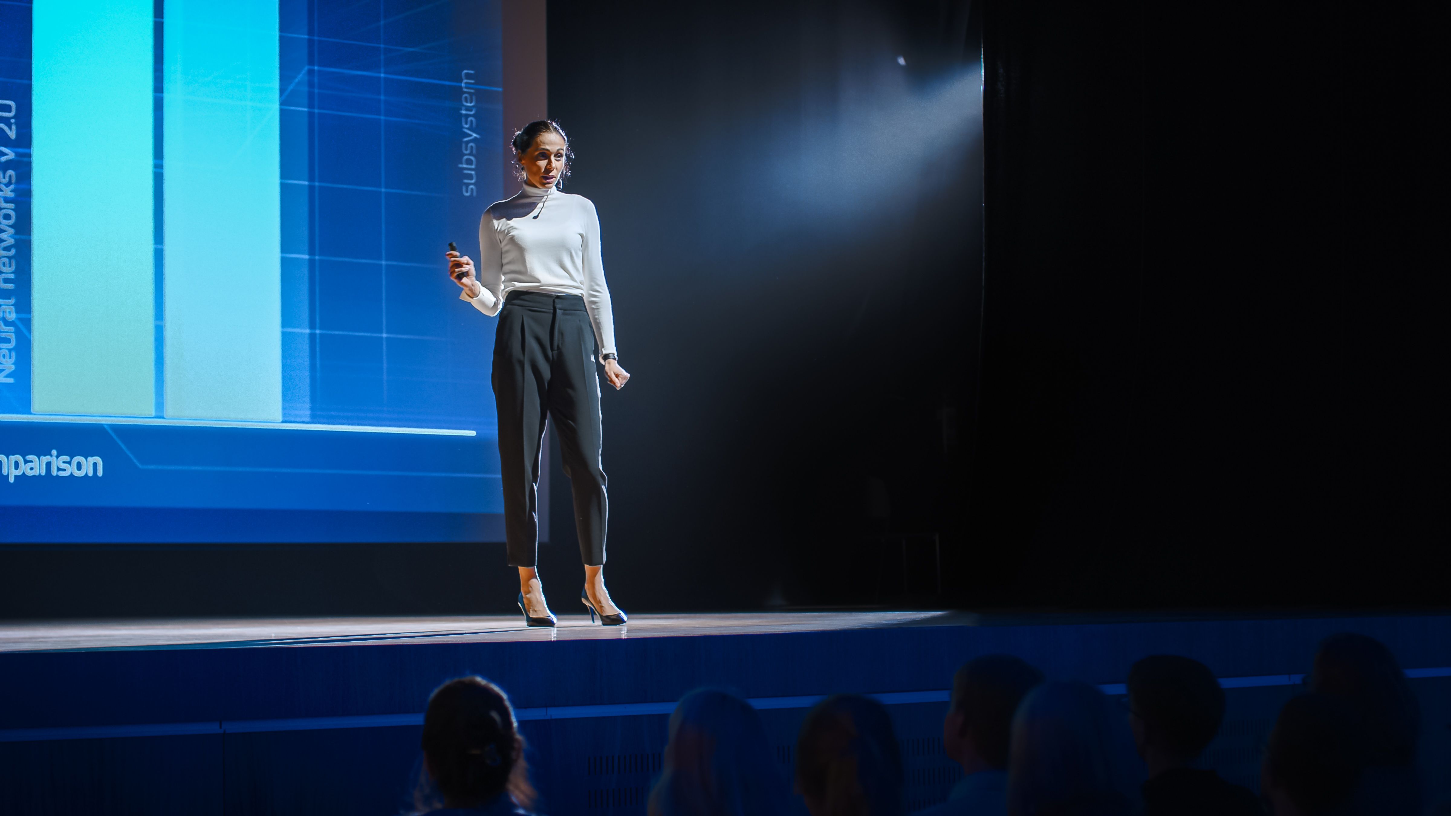 Tech Conference Stage: Visionäre Referentin spricht über Produkt. Neuronale Netzwerke, Künstliche Intelligenz, Big Data und Machine Learning. Infografiken auf großfeiner Leinwand. Live Startup Business Event