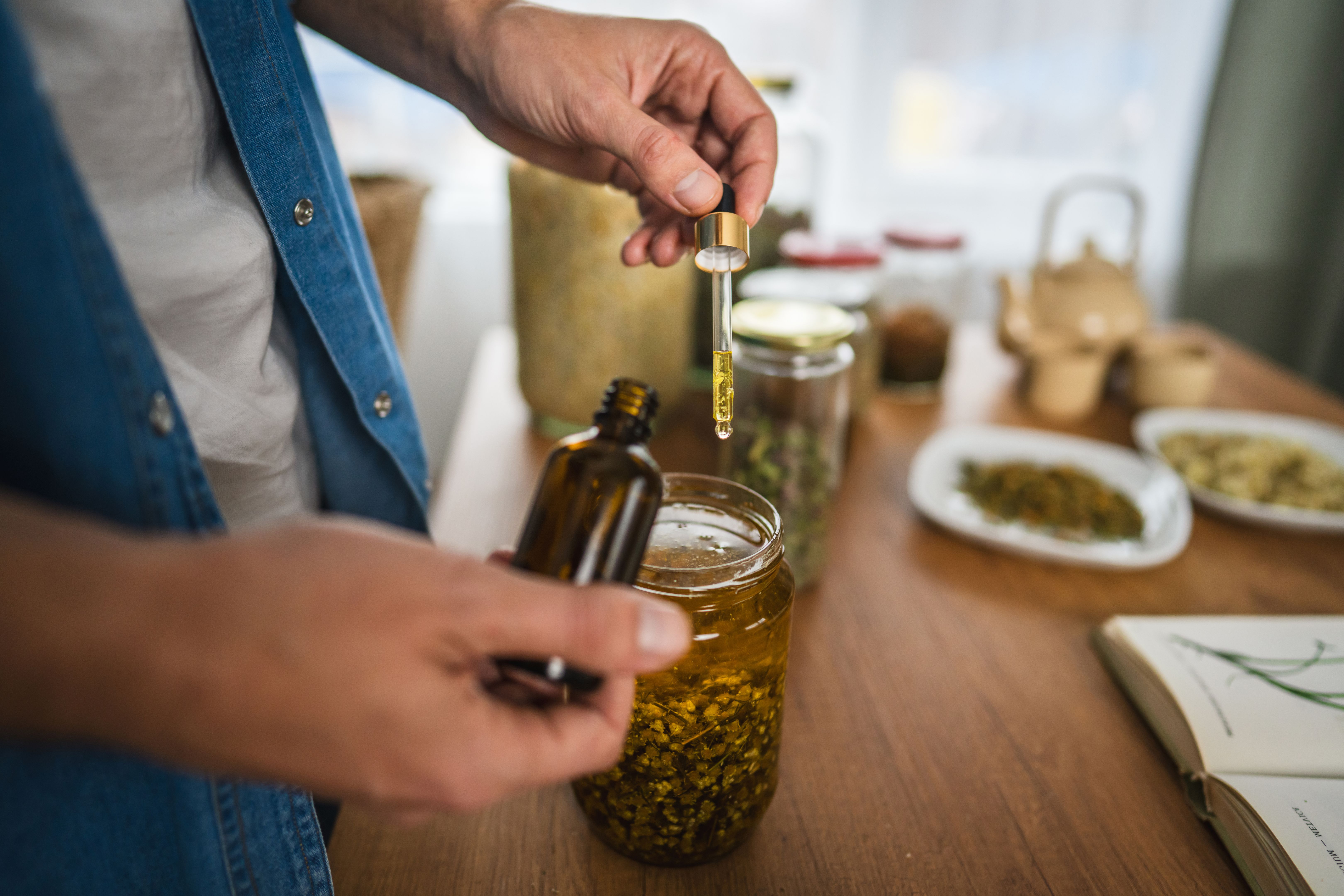 close up of man herbalist prepare natural oils in a rustic workshop close up of man herbalist prepare natural oils in a rustic workshop