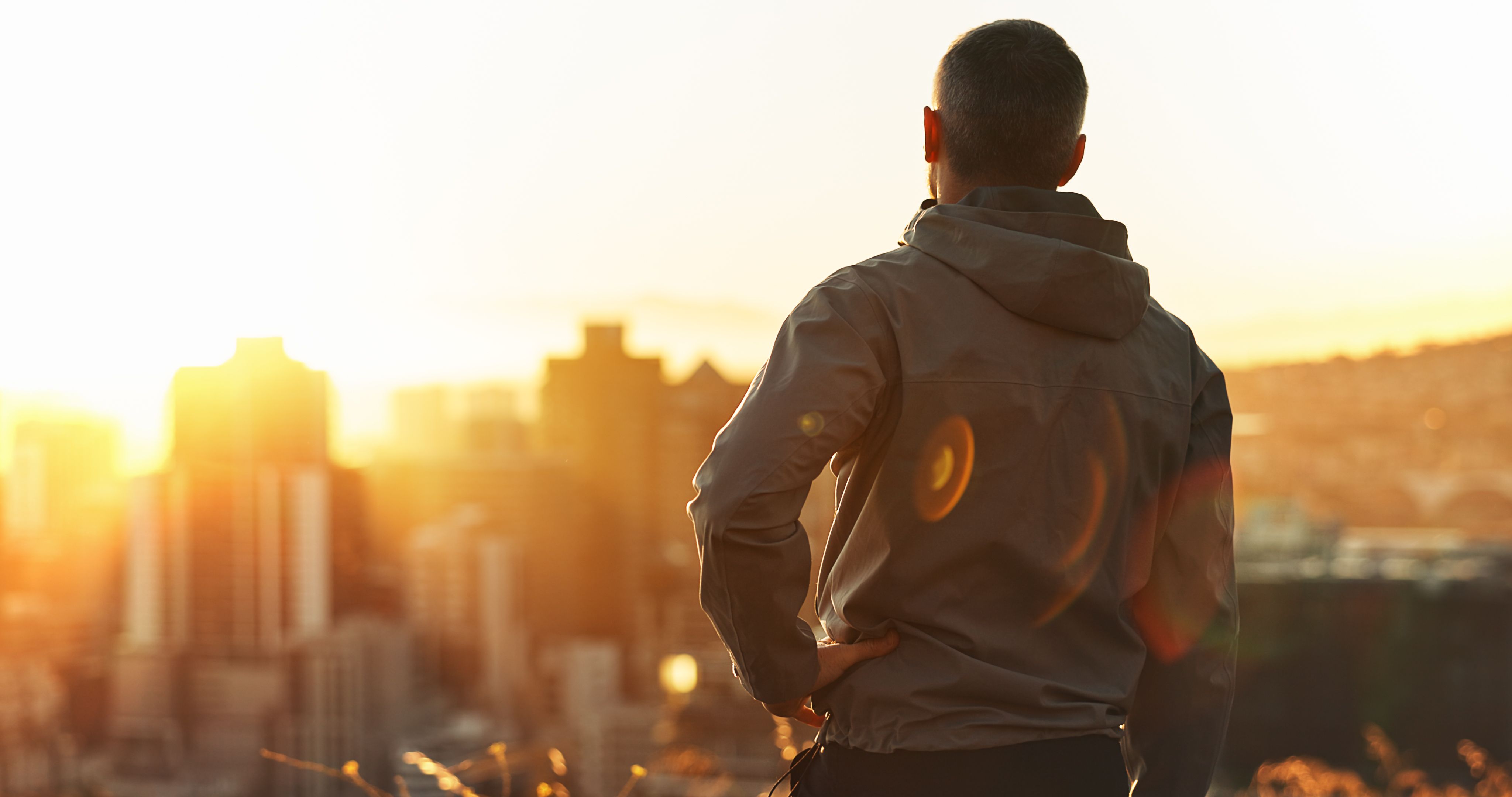 Man, runner and sunset with exercise, training and city view for fitness or cardio workout. Athlete, person and calm on mountain for wellness, health and summer marathon performance or endurance
