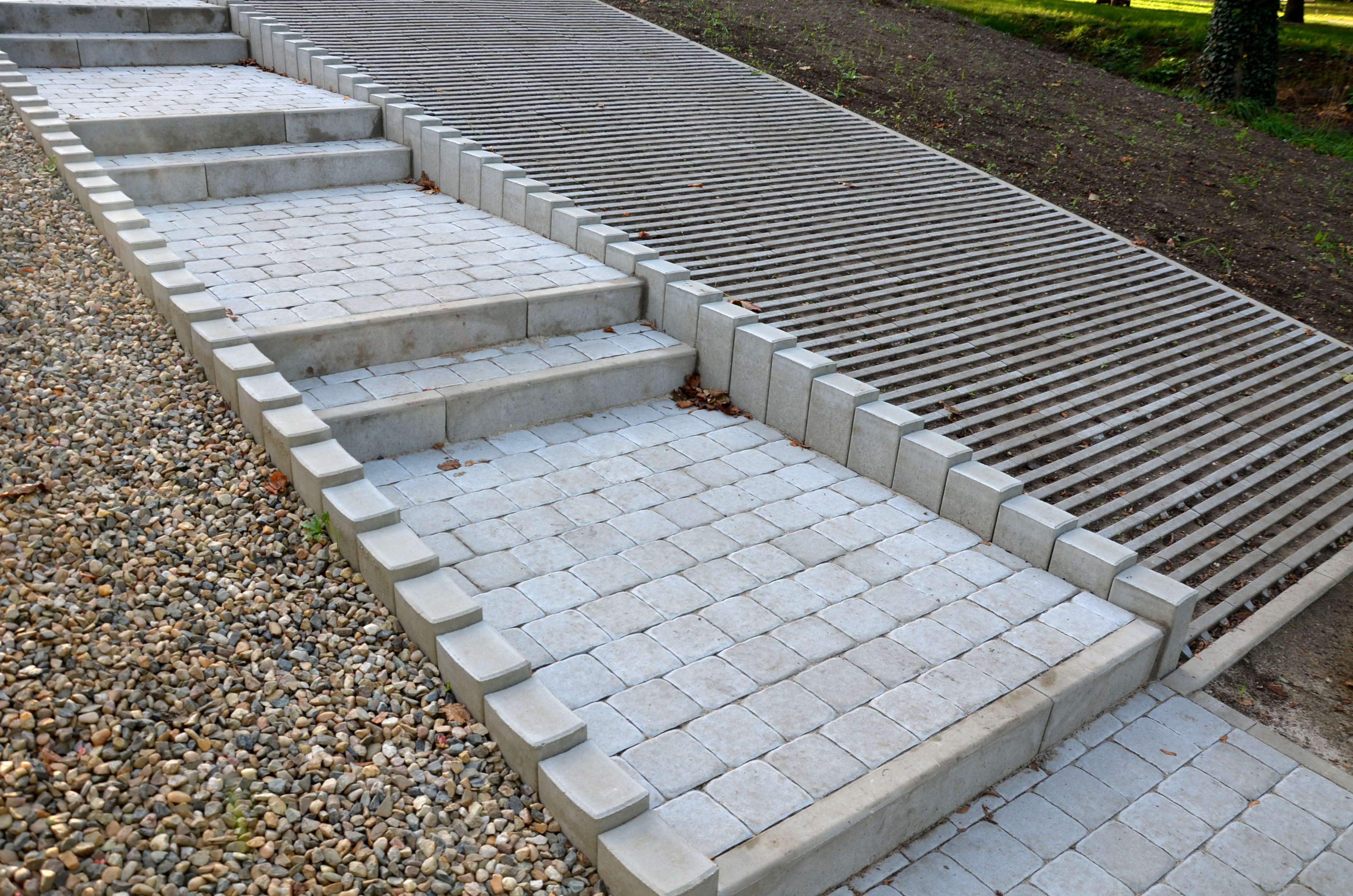 solution of paved parking lot surfaces and roads with the ability to absorb water directly from the surface and on the spot concrete tiles have joints are filled with soil where the lawn grows