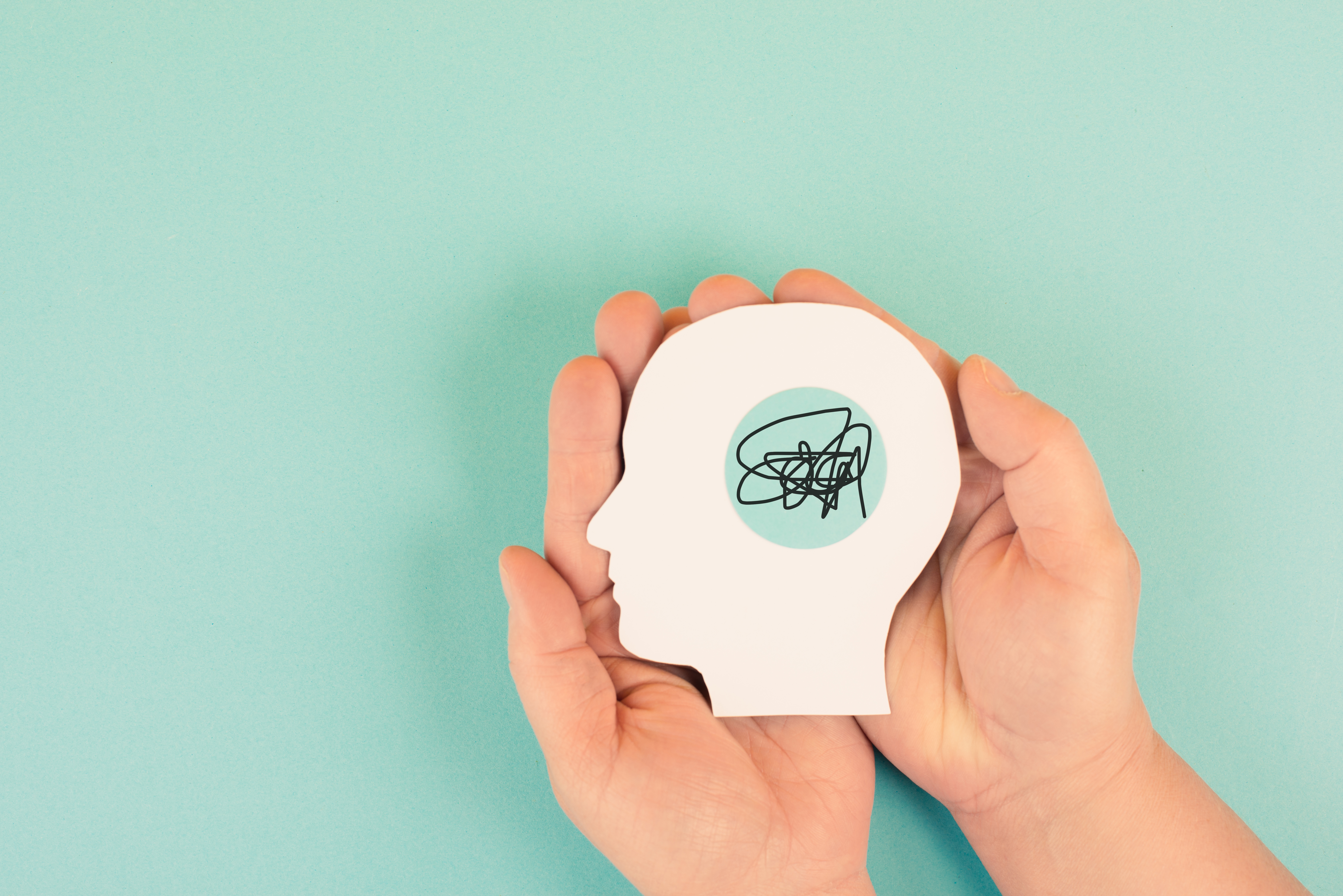 Hands holding a silhouette of a human head, attention deficit hyperactivity disorder, ADHD symptom, mental health Hands holding a silhouette of a human head, attention deficit hyperactivity disorder, ADHD symptom, mental health