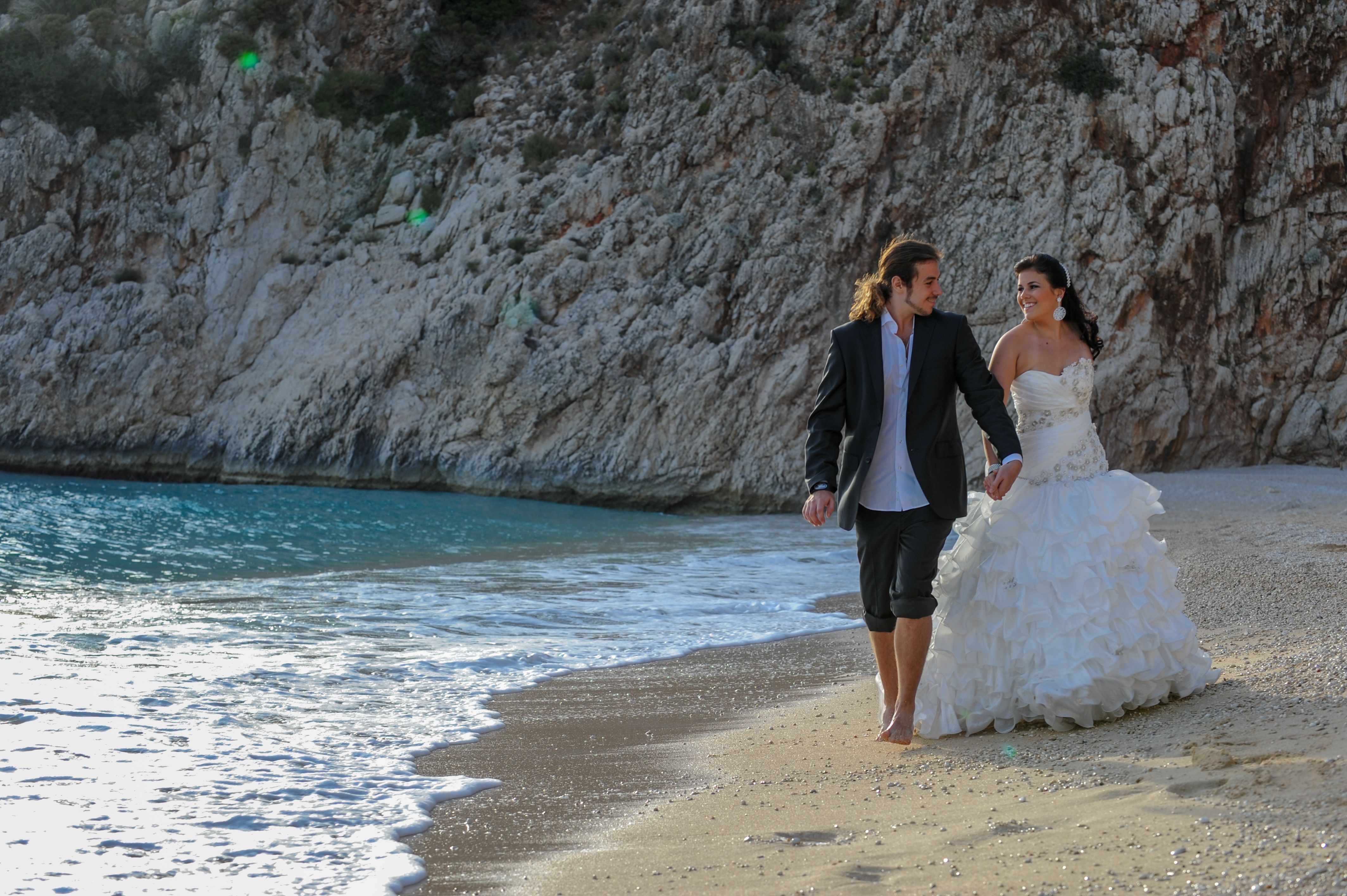 Bride and groom walking on the beach
