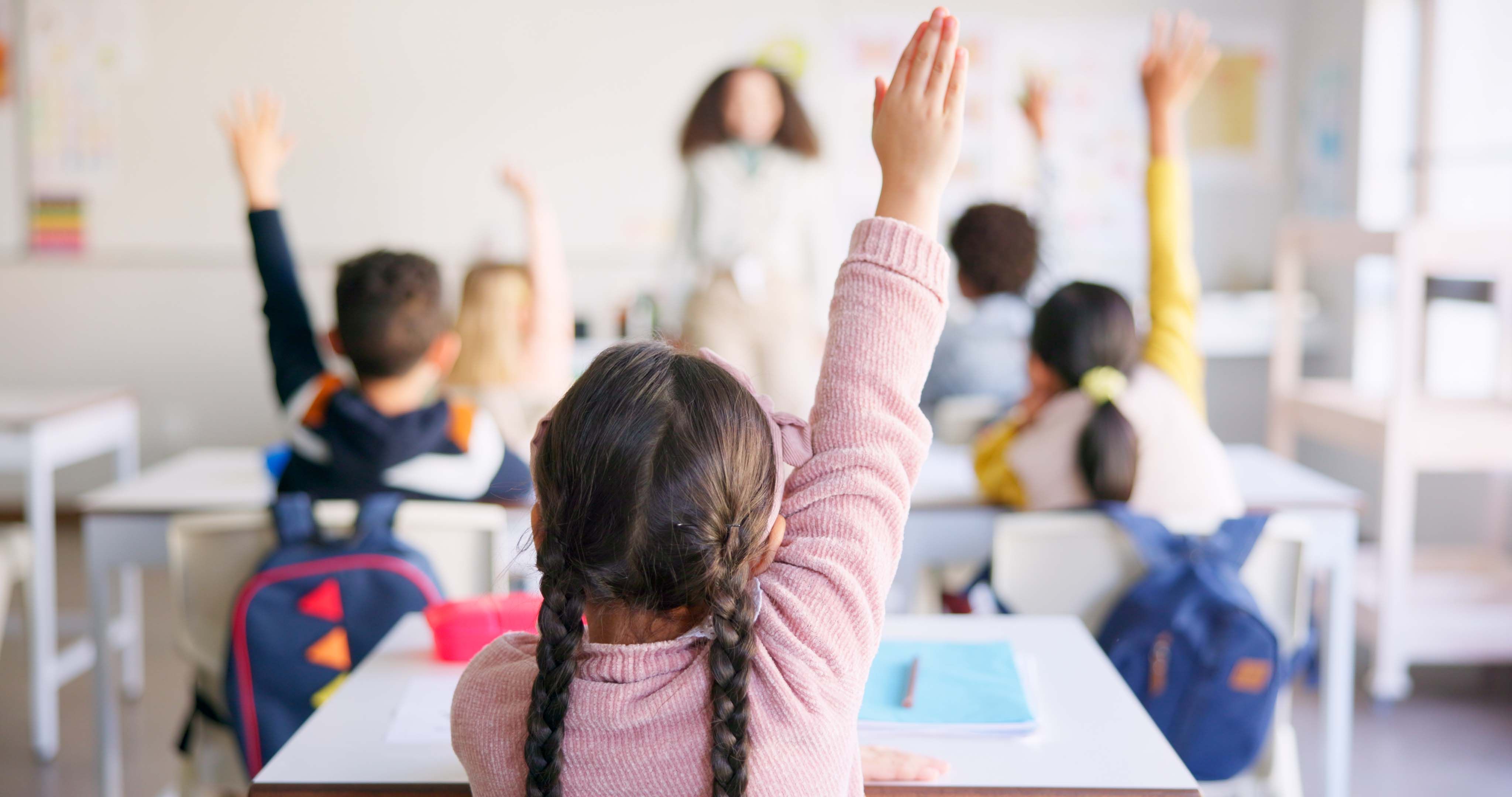Bildung, erhobene Hand und Schülerin im Klassenzimmer mit Lehrer zum Lernen, Diskutieren und Wissen. Helfen Sie Schülern, lernen und Kinder mit Fragen an Erzieherinnen oder Nachhilfelehrer in der Schule.