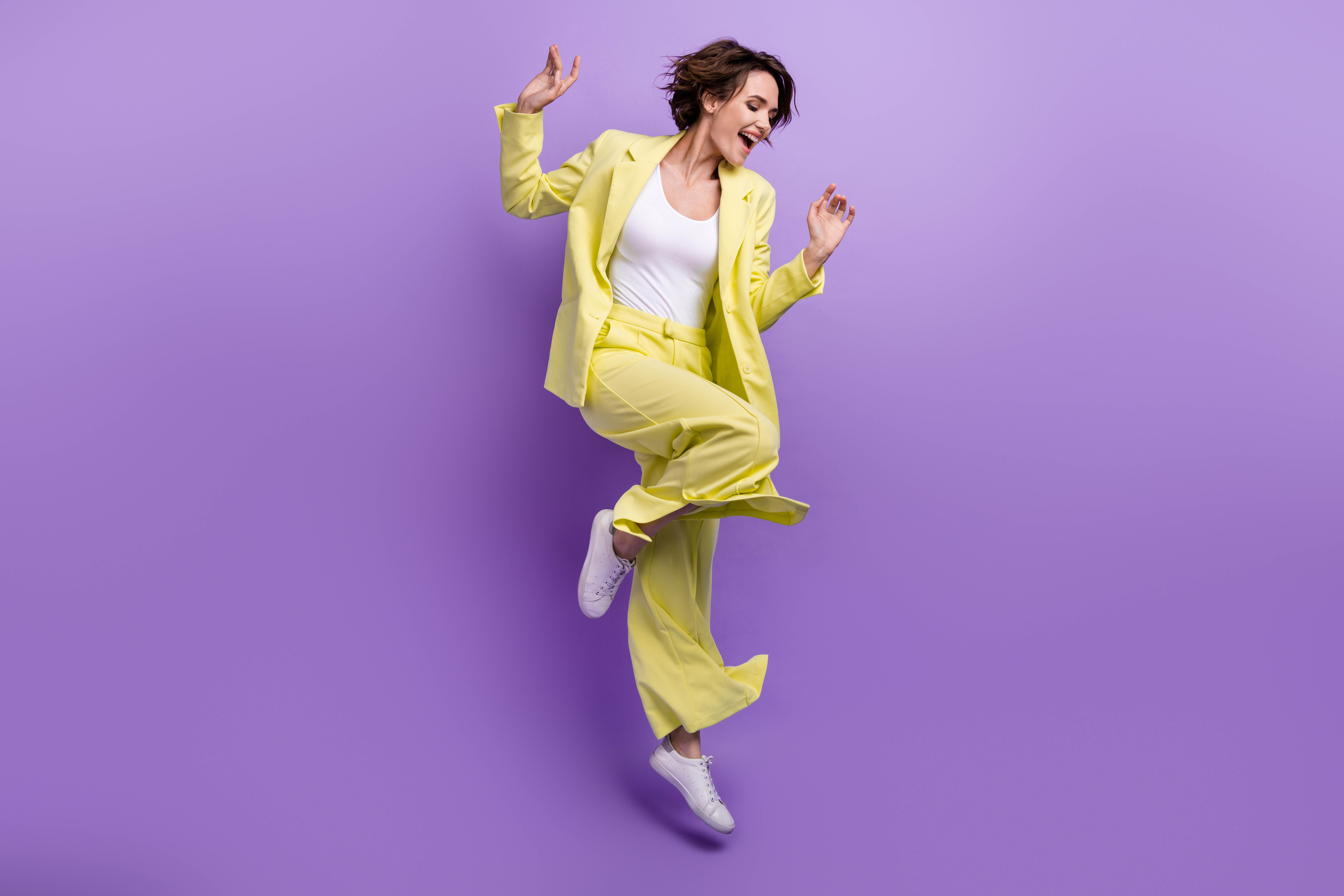 Full size photo of carefree overjoyed happy woman dance motion wear lime yellow flared outfit jumper isolated over purple color background Full size photo of carefree overjoyed happy woman dance motion wear lime yellow flared outfit jumper isolated over purple color background