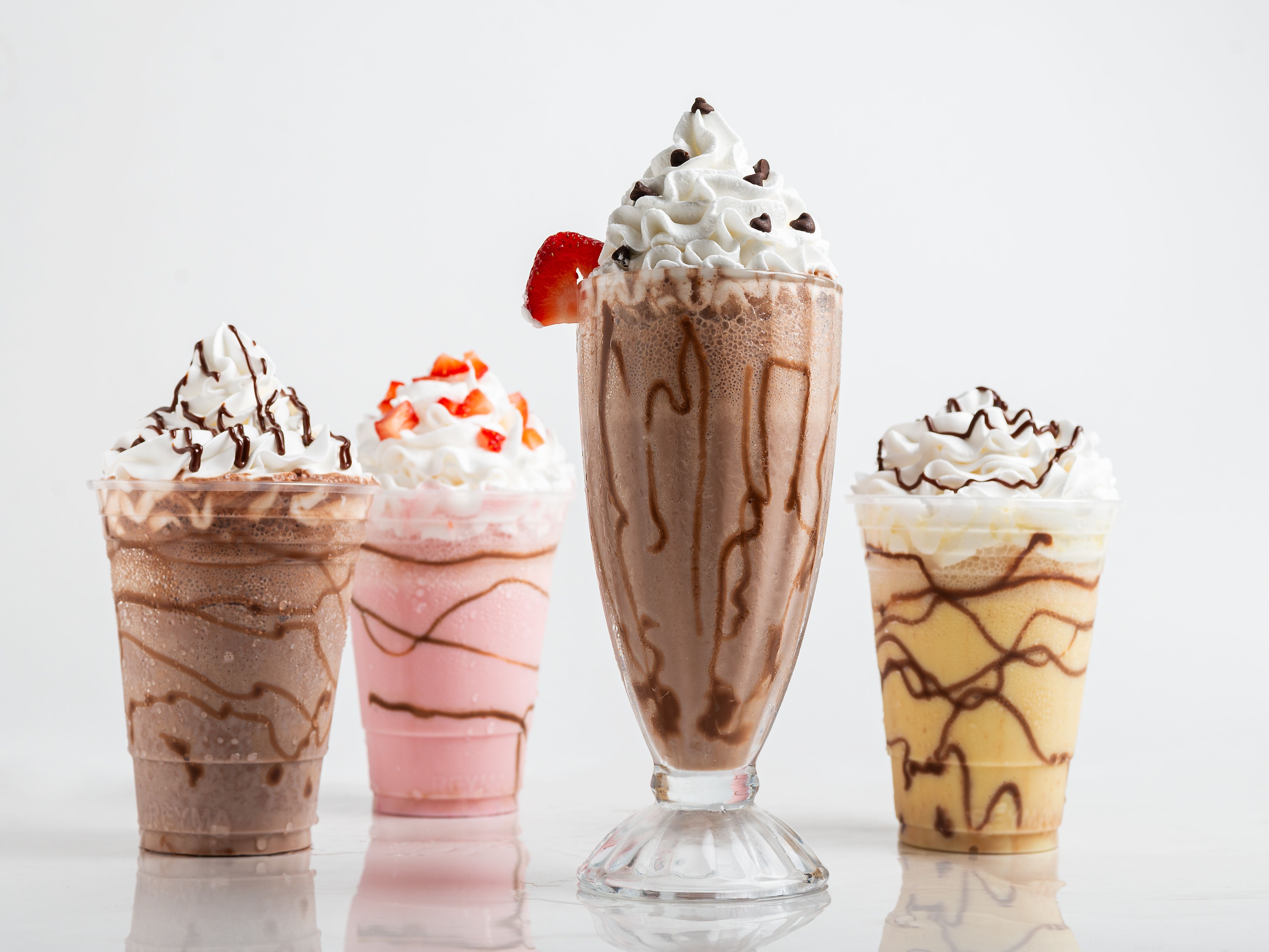 Quattro invitanti varianti di milkshake: cioccolato, fragola, vaniglia e una miscela di moka