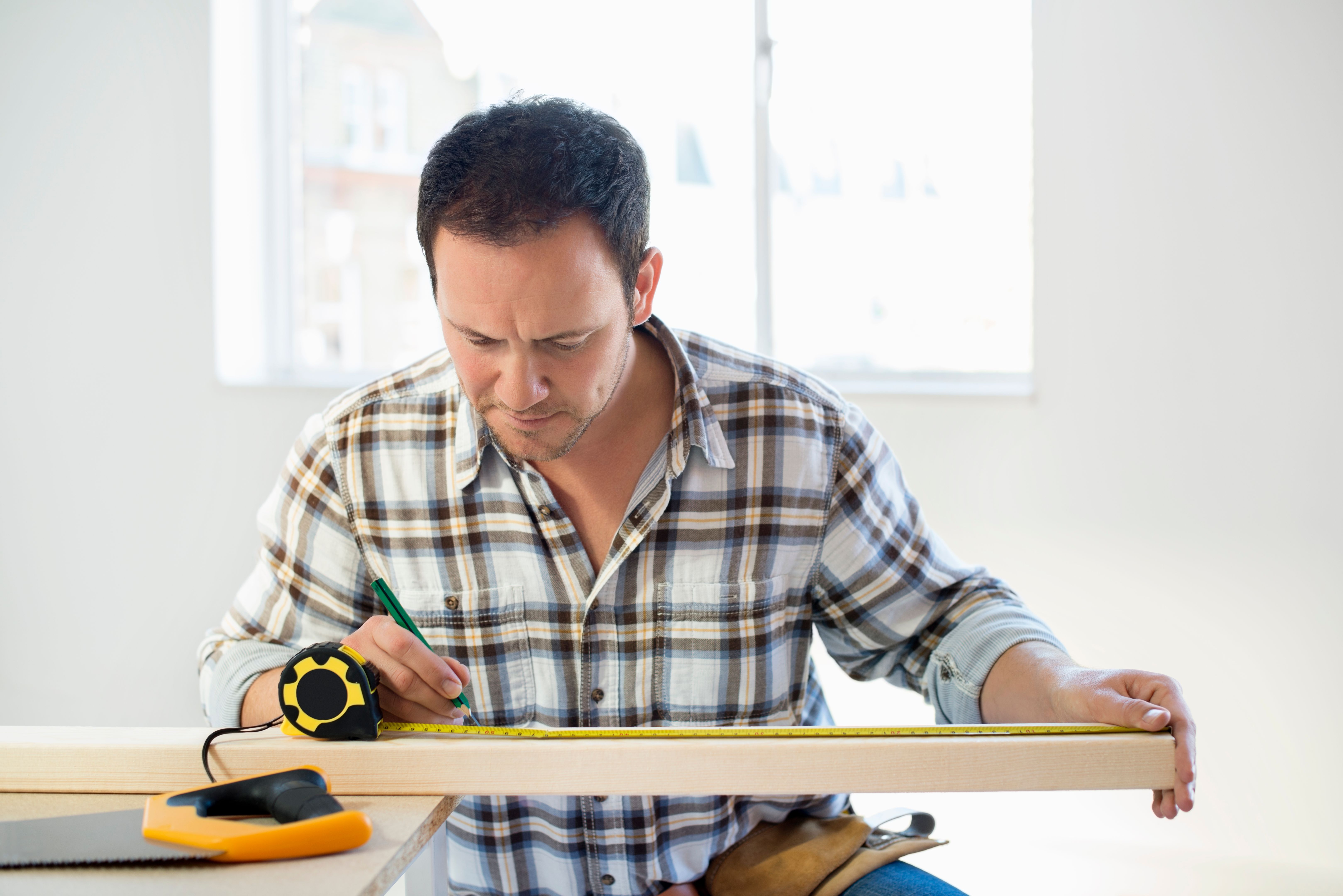 Carpenter Measuring Wood