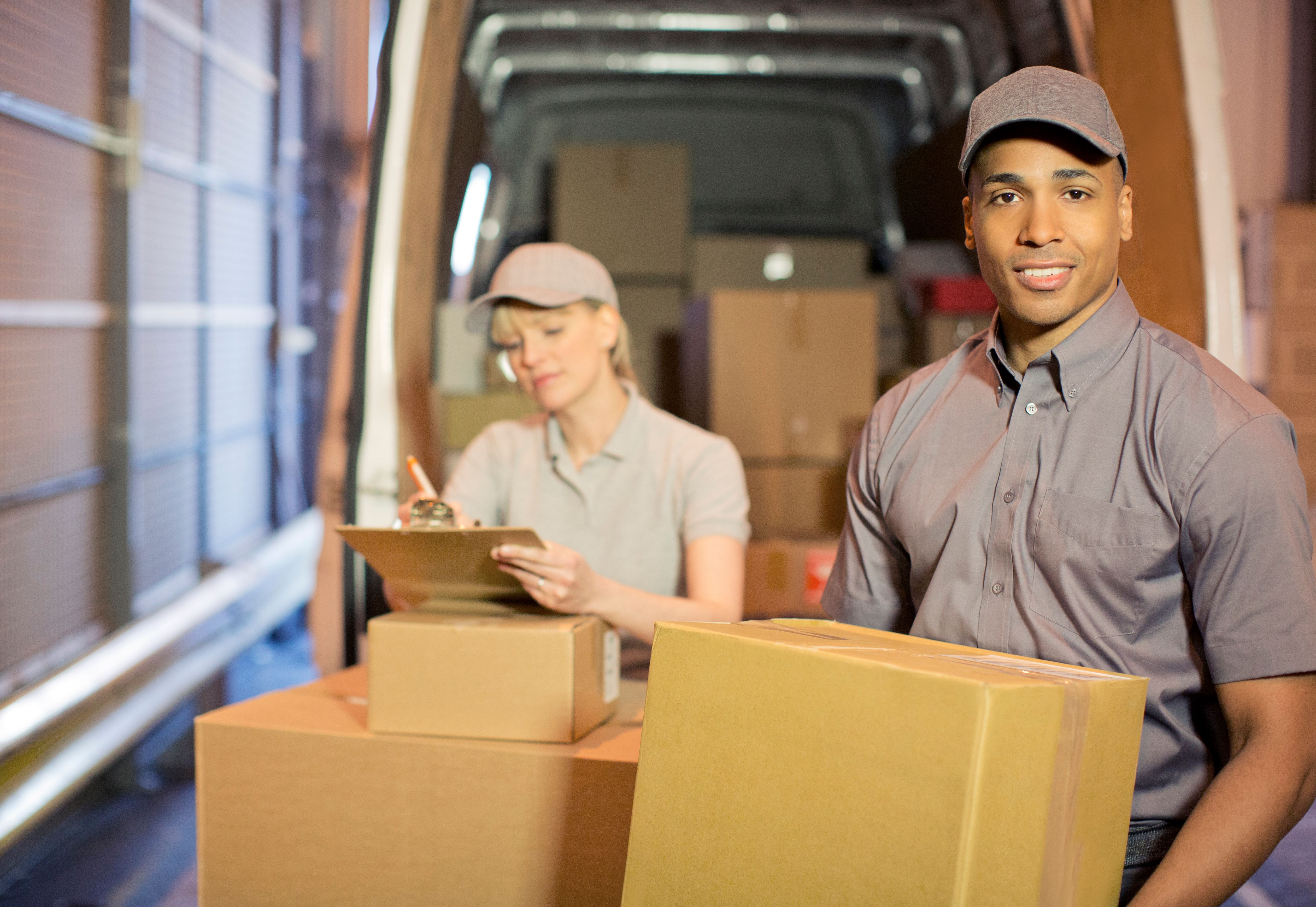 Delivery people loading boxes into van