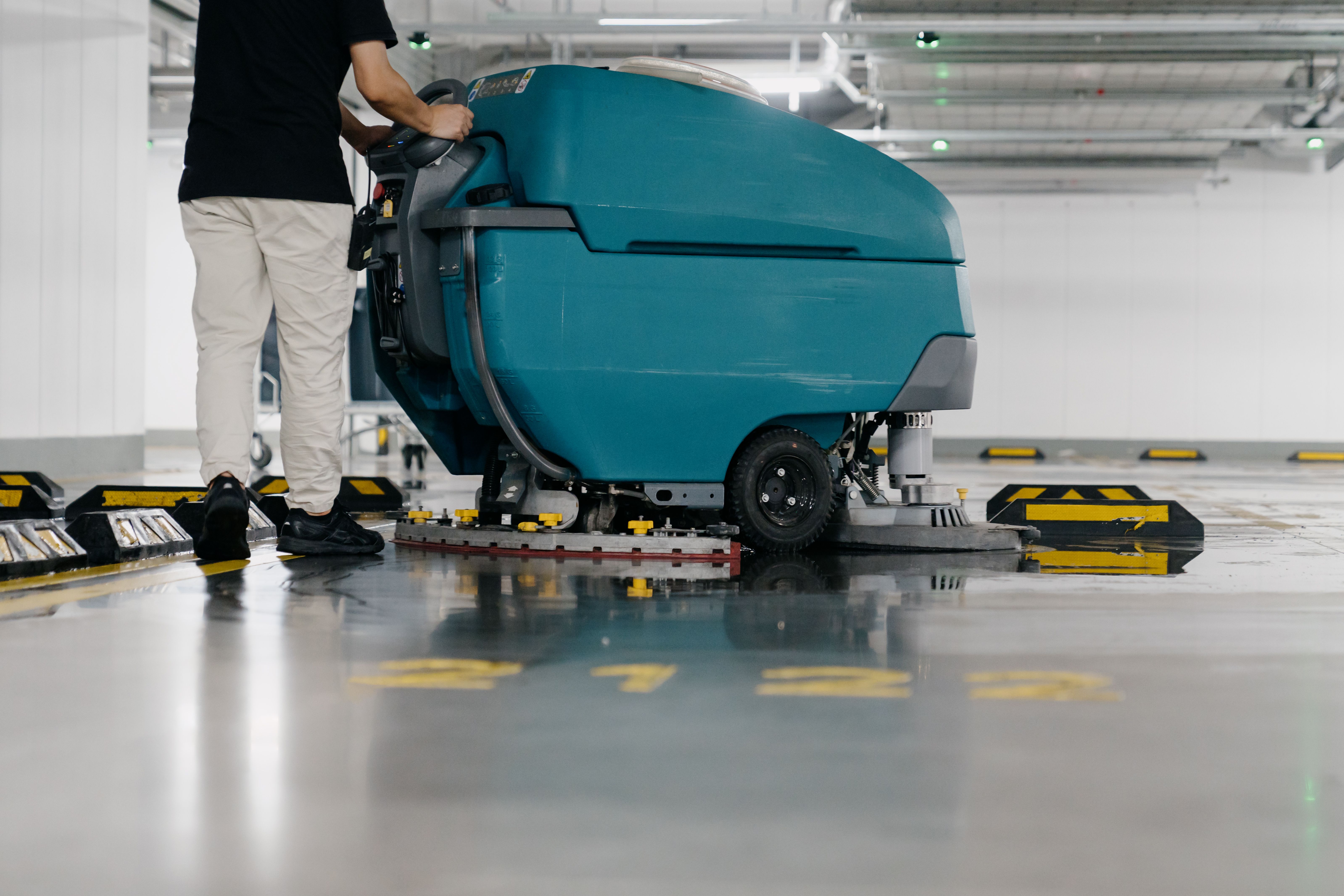 Cleaners are cleaning the parking lot with a machine