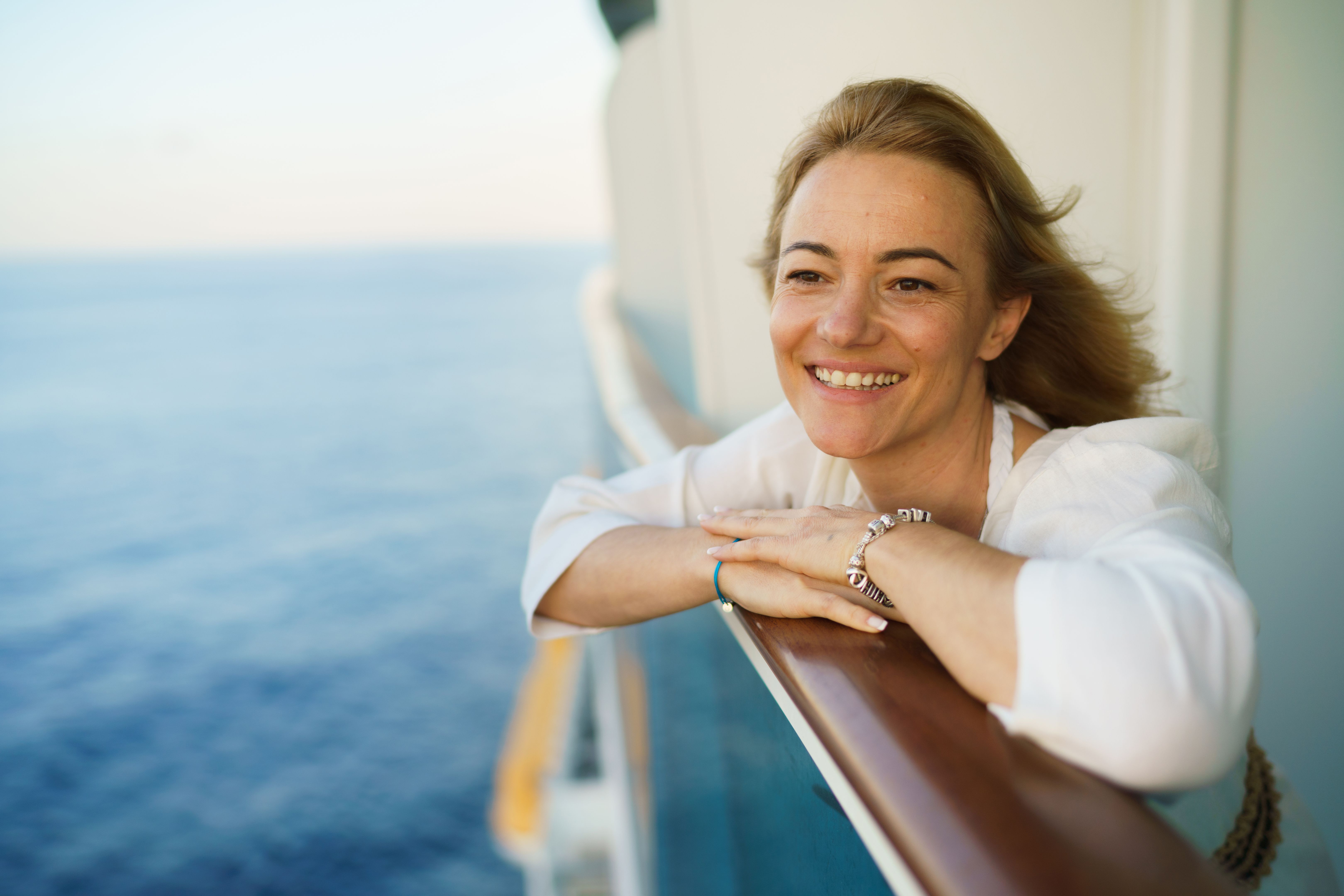 Happy woman looking at sea from a cruise ship
