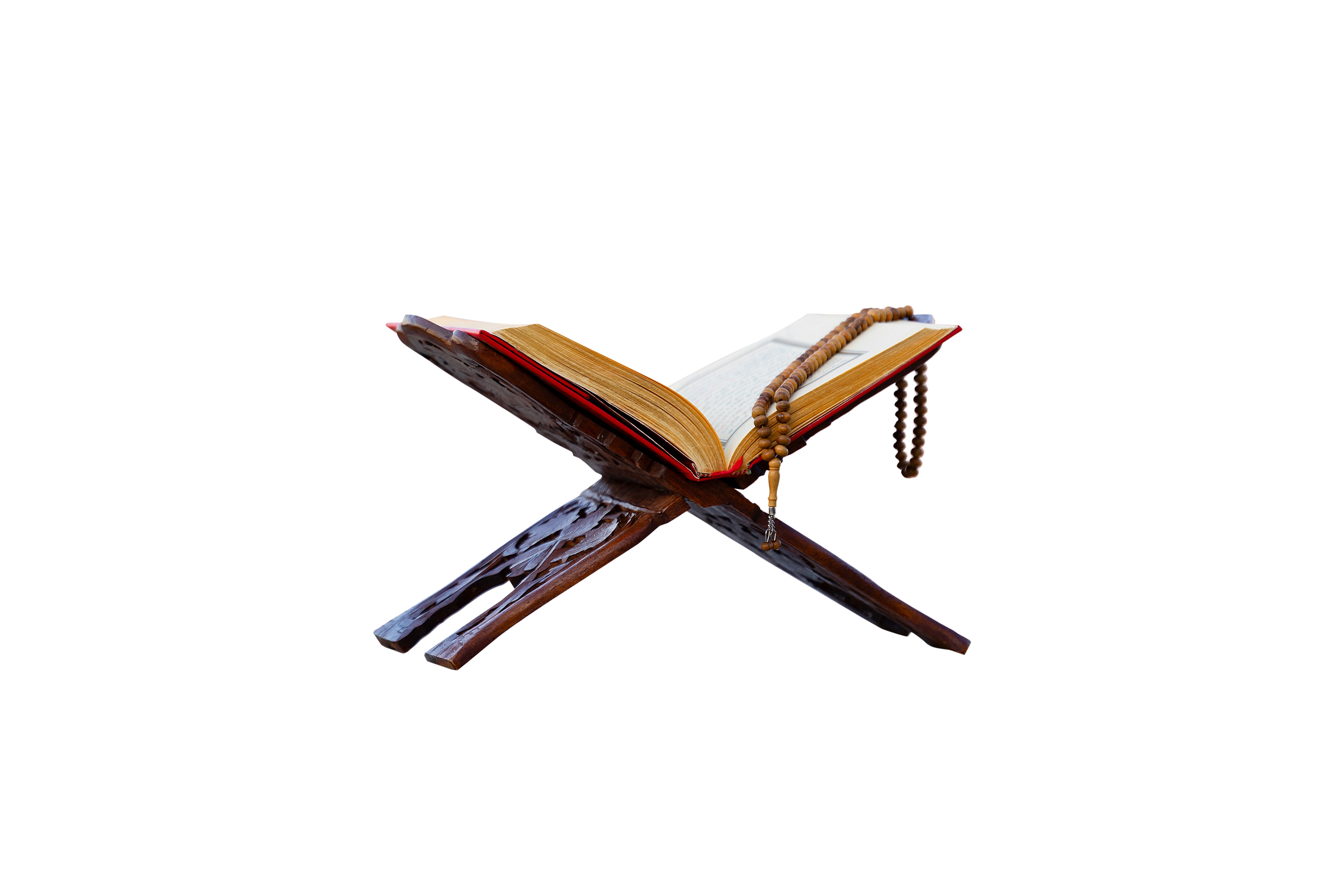 A close-up shot of an open Quran on a traditional wooden stand