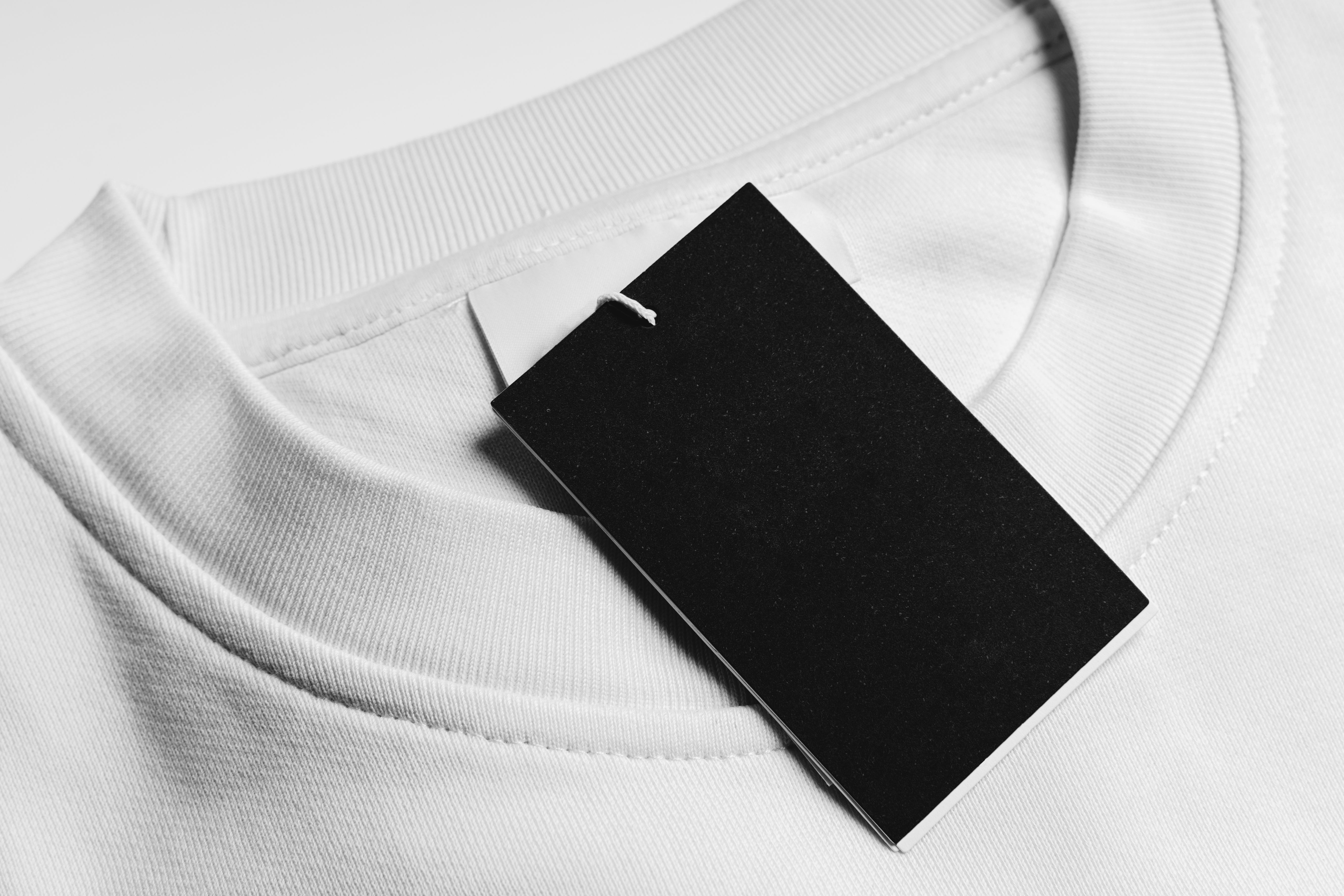 Close-up of a blank tag on white clothing. Resource for mockup design.