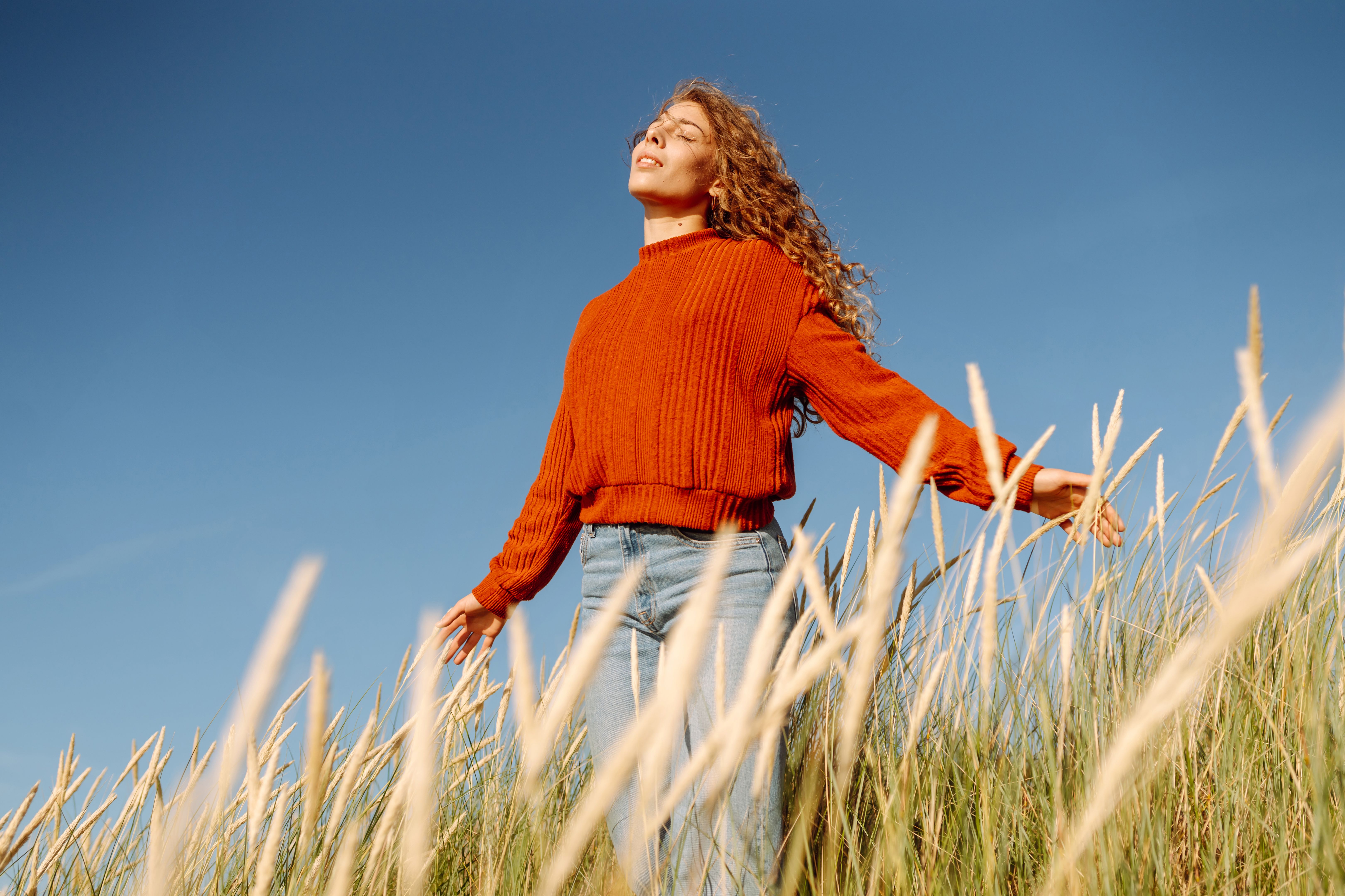 Beauty woman enjoying nature outdoors in tall grass.