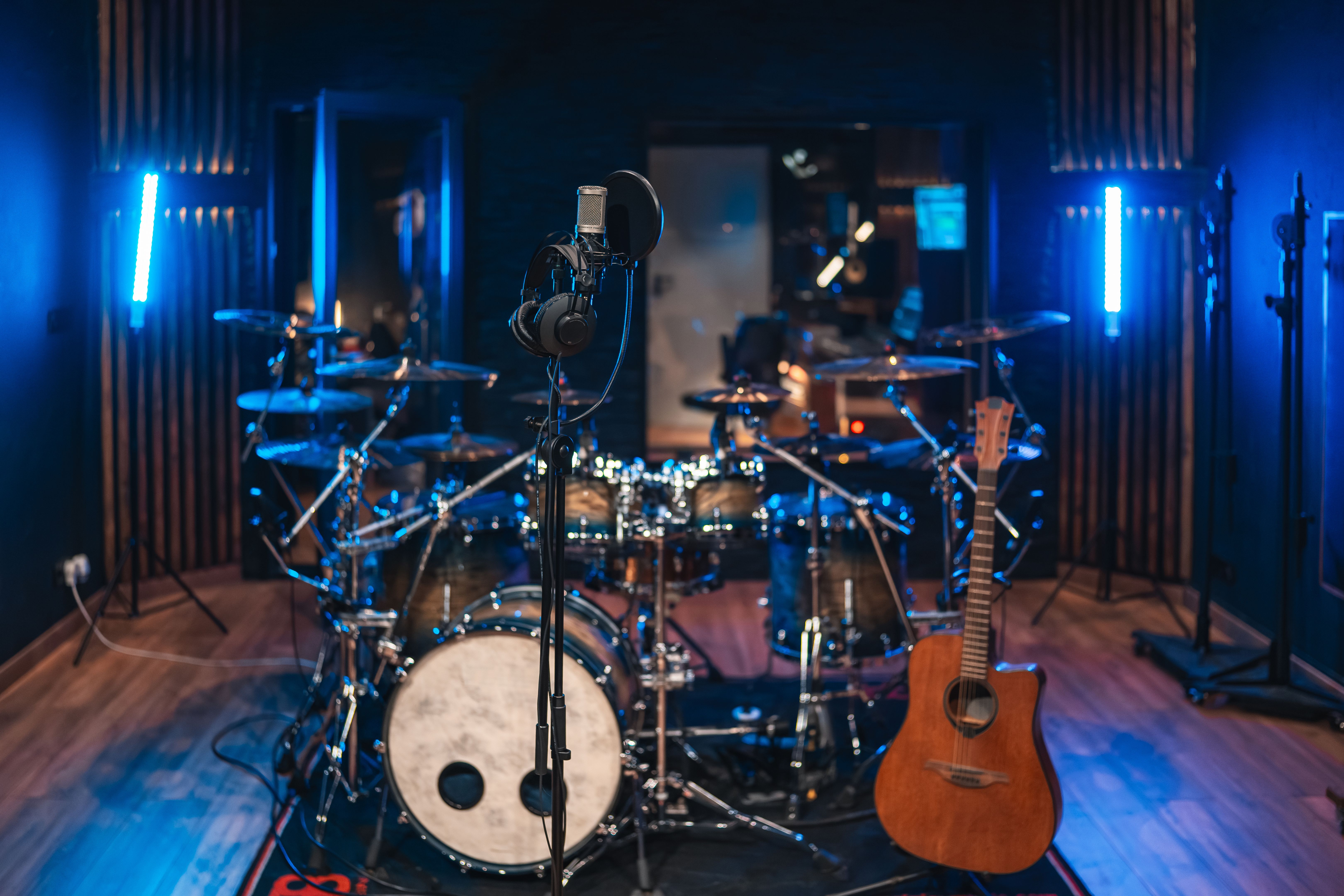 Recording studio ready for a music session with drum kit, guitar, and microphone