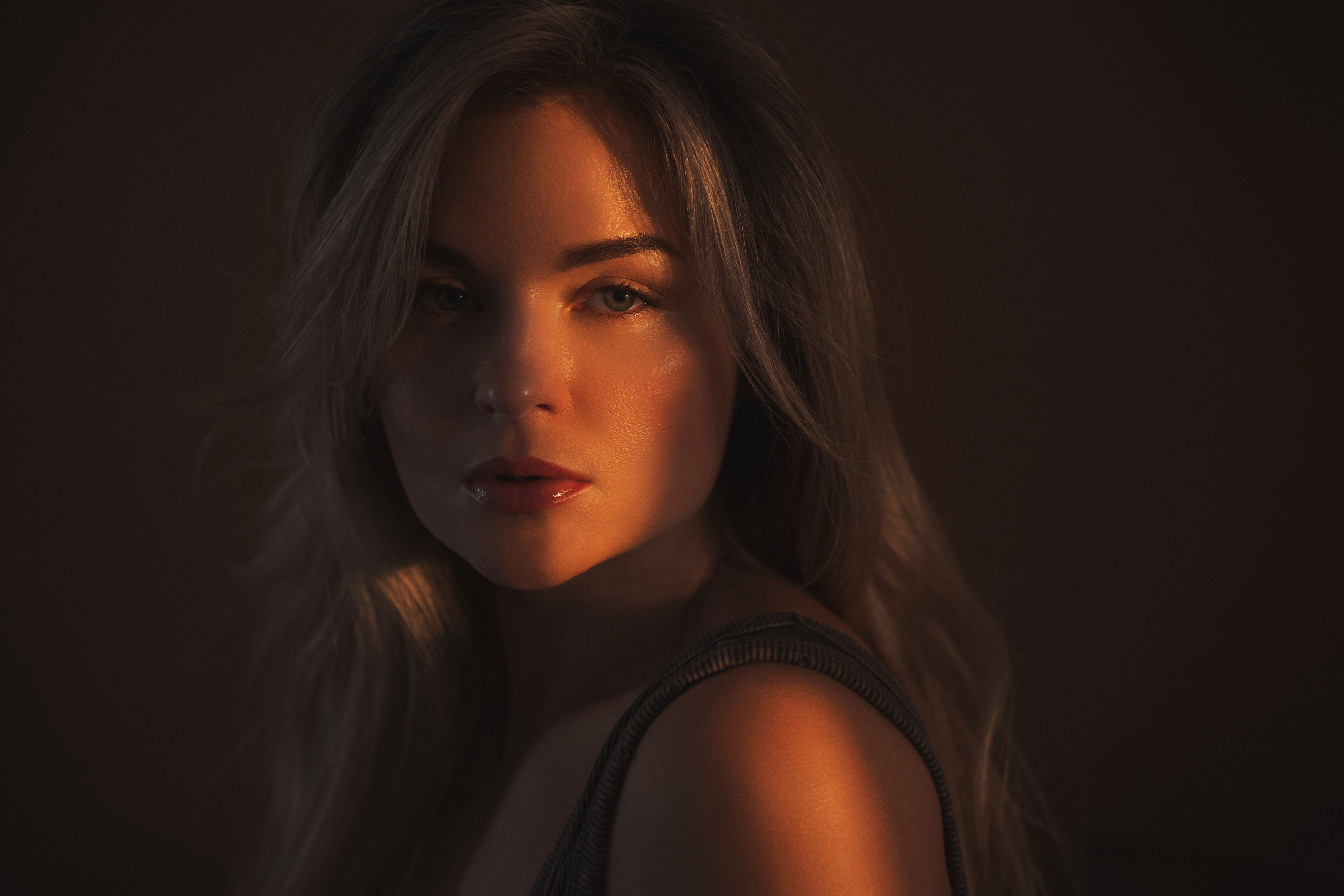 Artistic Portrait of Woman in Warm Shadow Lighting with Intense Gaze